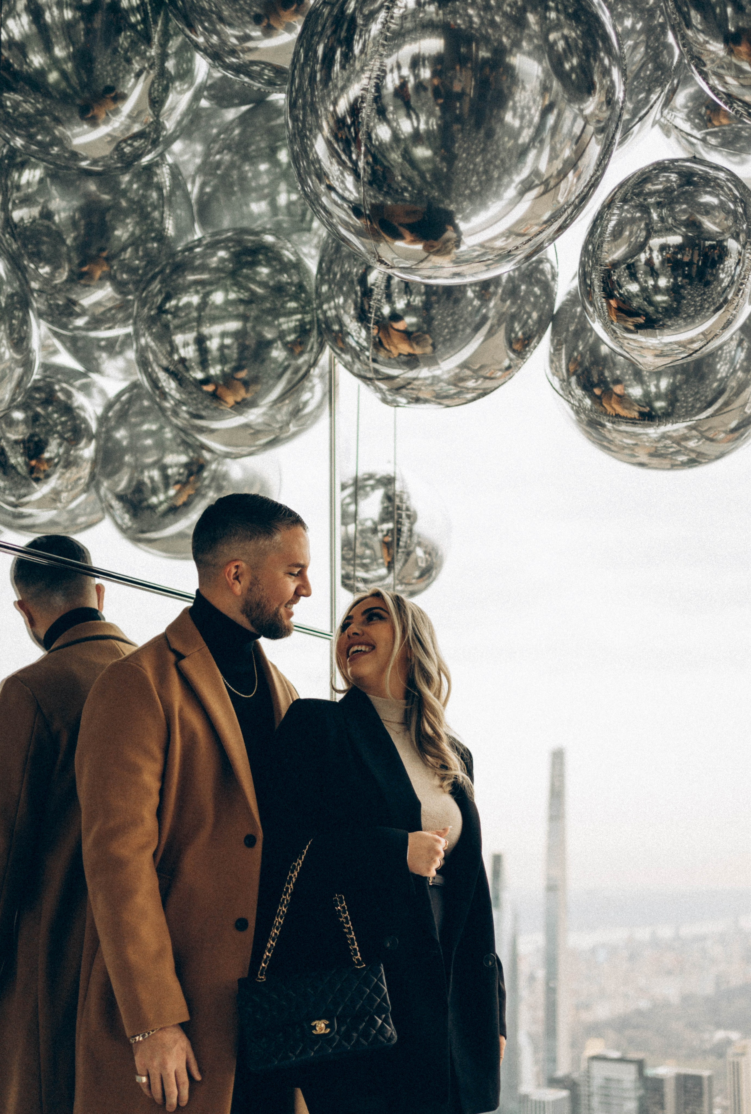 Emotional hug after proposal near Empire State Building.