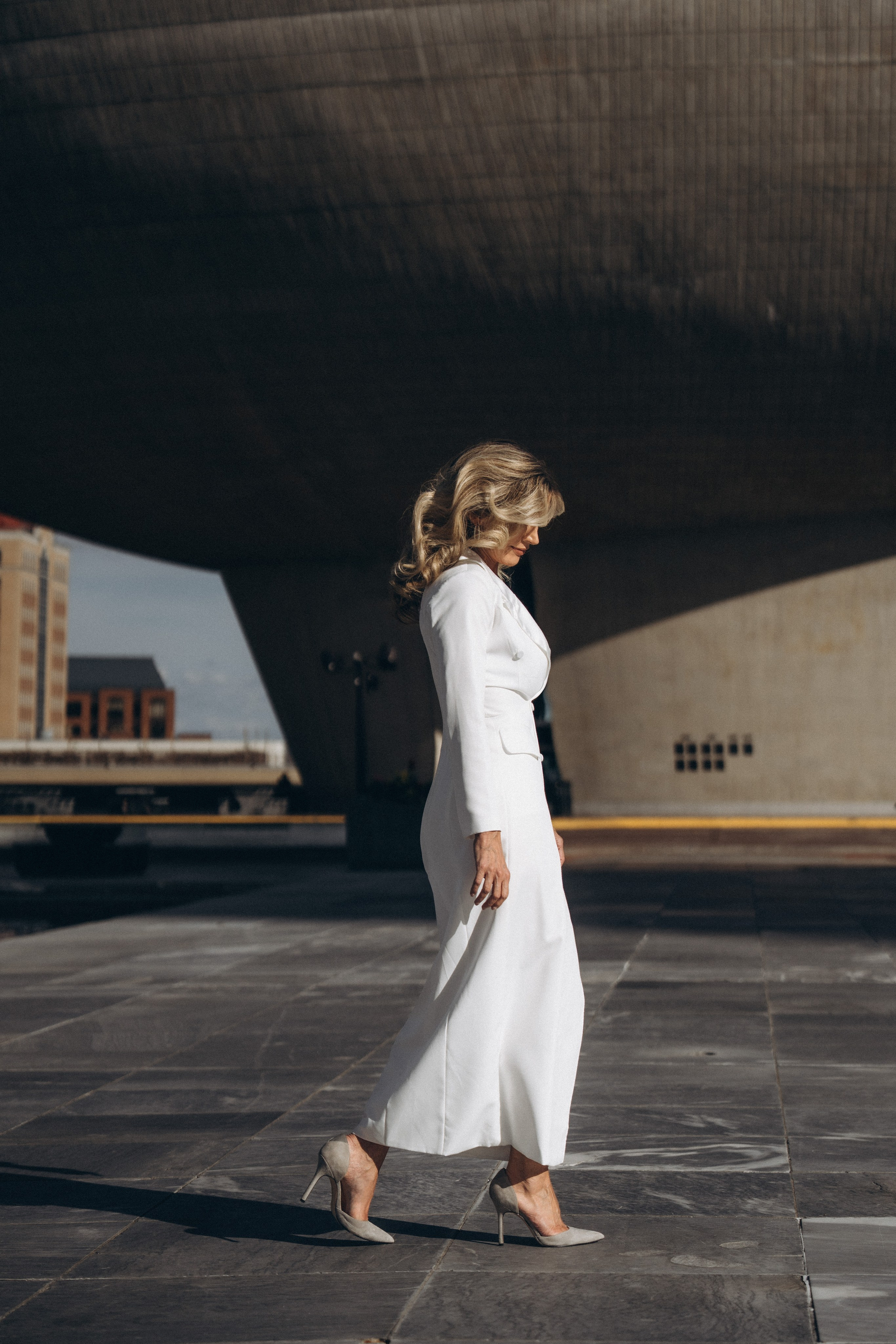 Smiling bride in Glens Falls park with fountain.