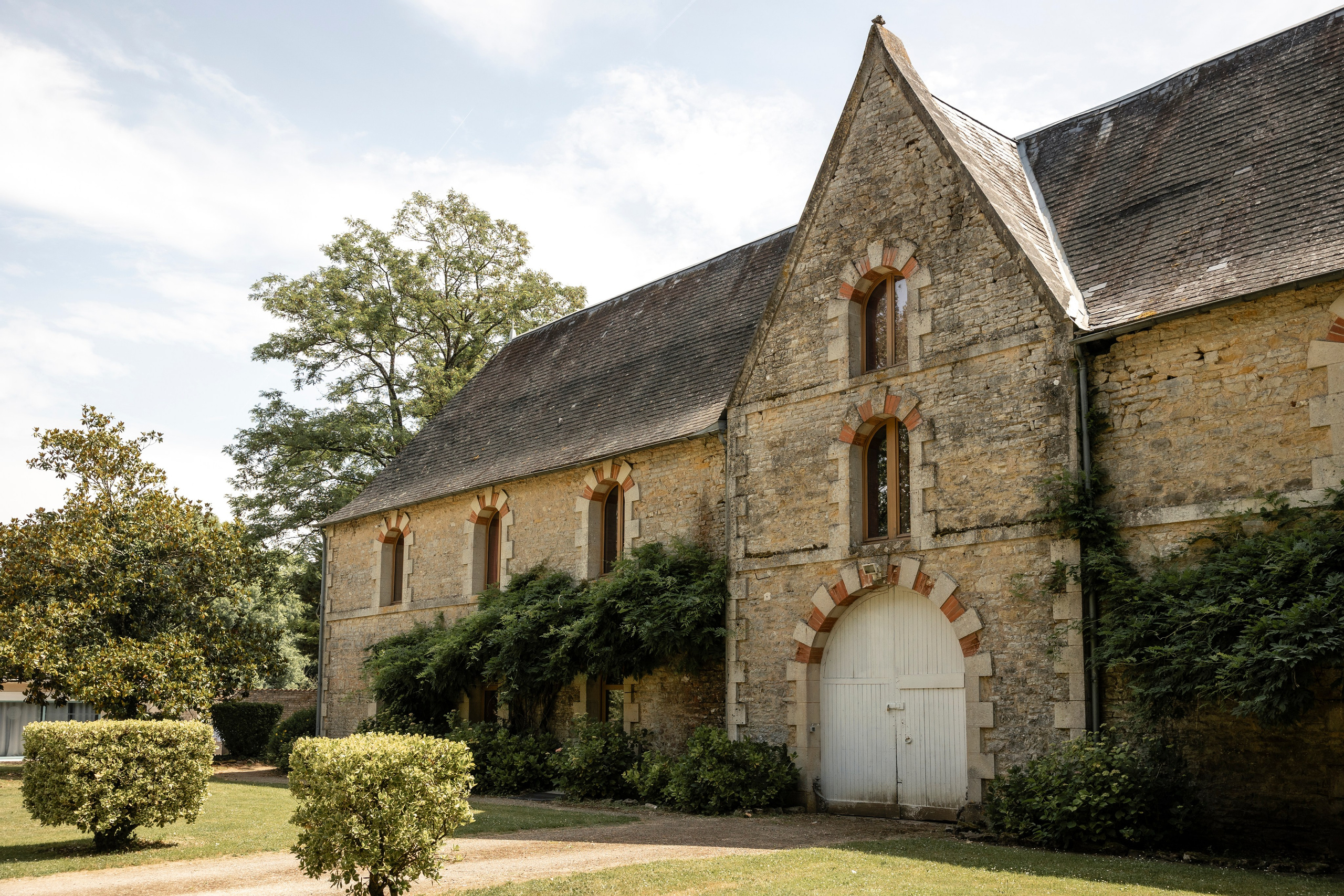 Stone outbuilding with an arched door in the grounds of Château de la Borderie