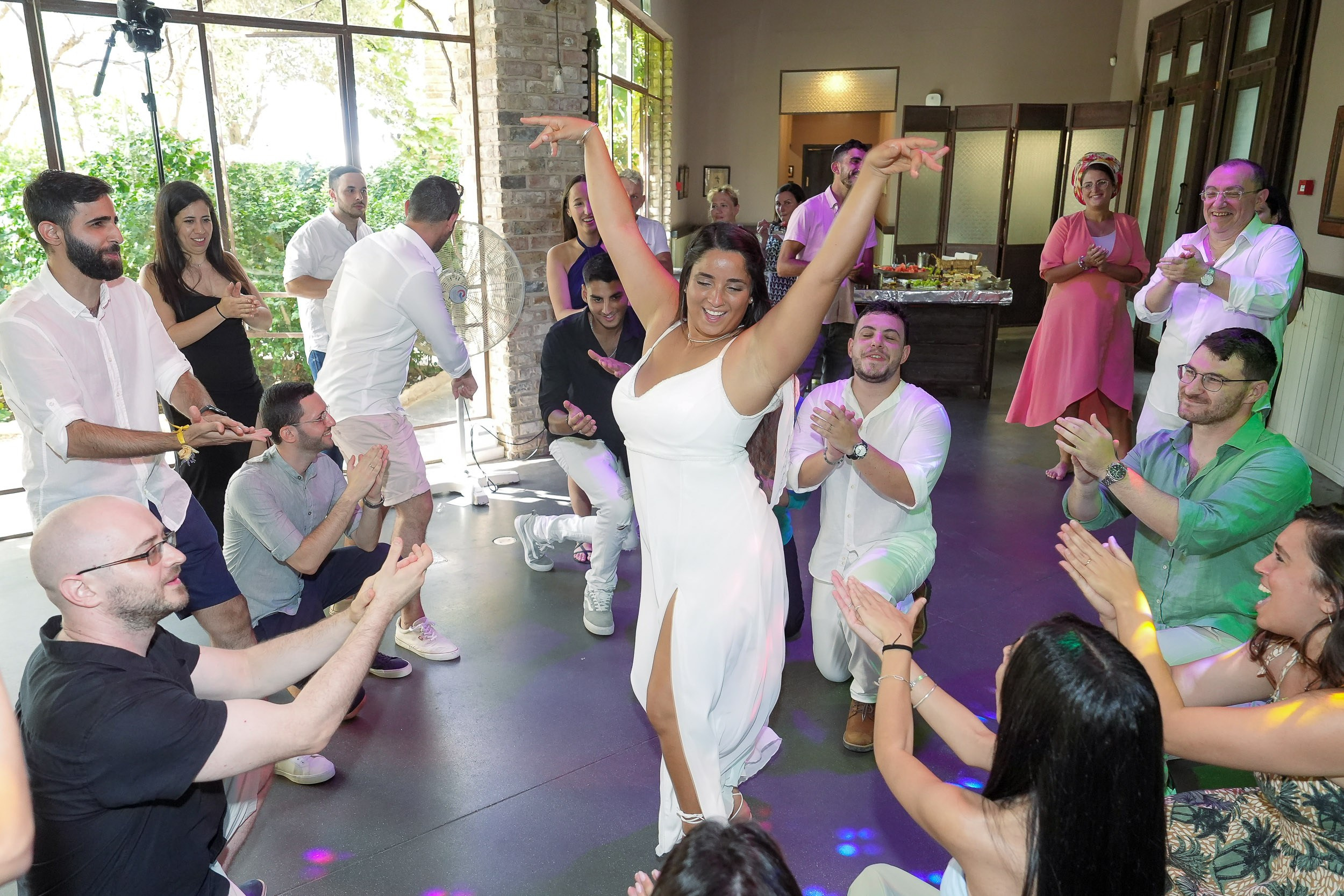 Talia performs a traditional dance surrounded by cheering guests