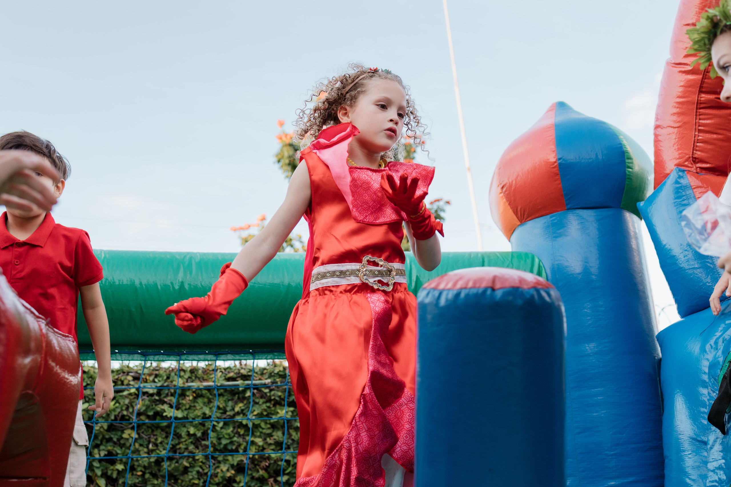 Menina fantasiada de Elena de Avalor brincando pula-pula