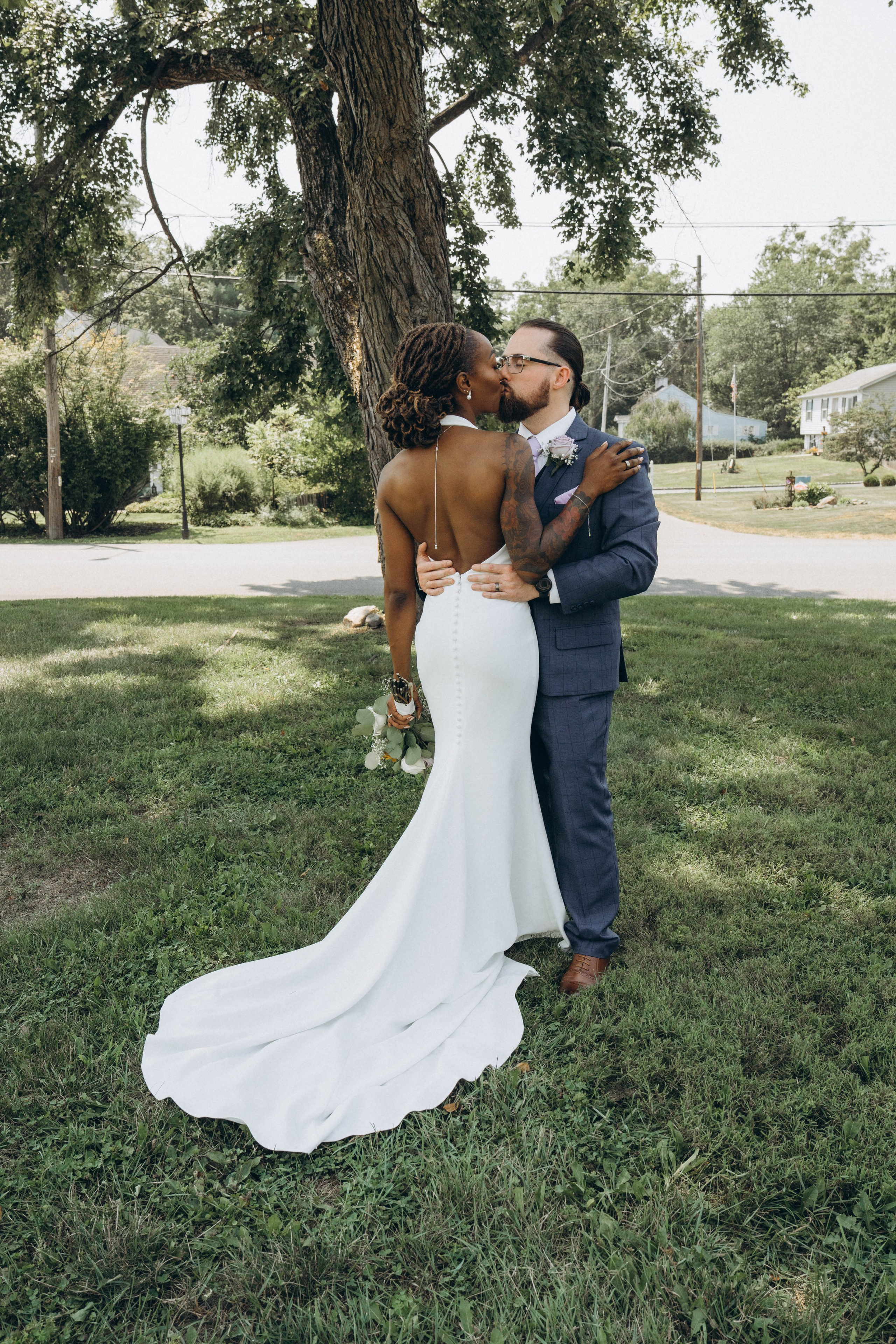 Candid kiss between bride and groom captured in natural light