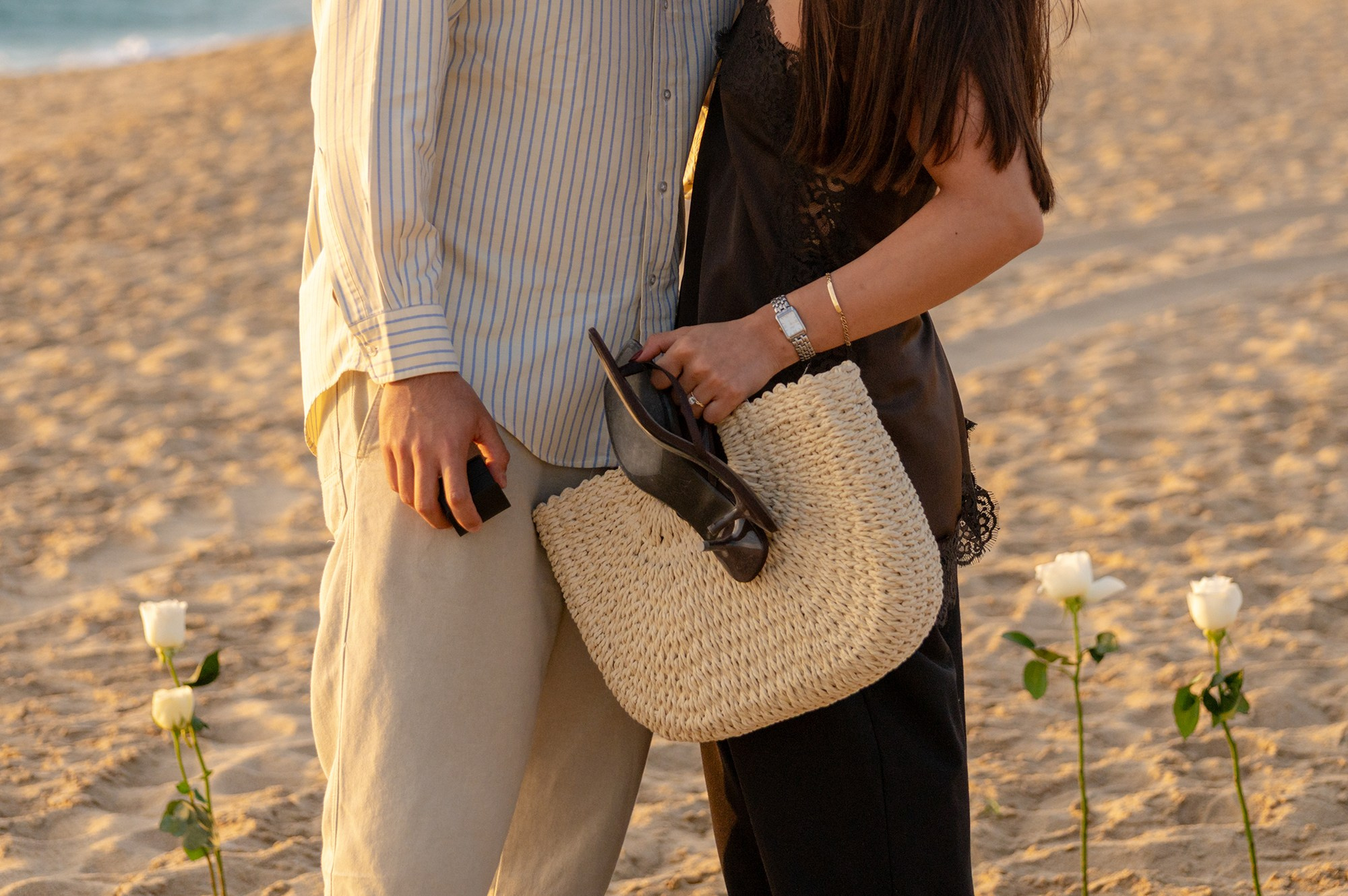 a ring on her hand, and a box on hs hand after make the big question of a proposal, in front of the pacific, around withe roses, playa mangos Todos Santos Baja sur