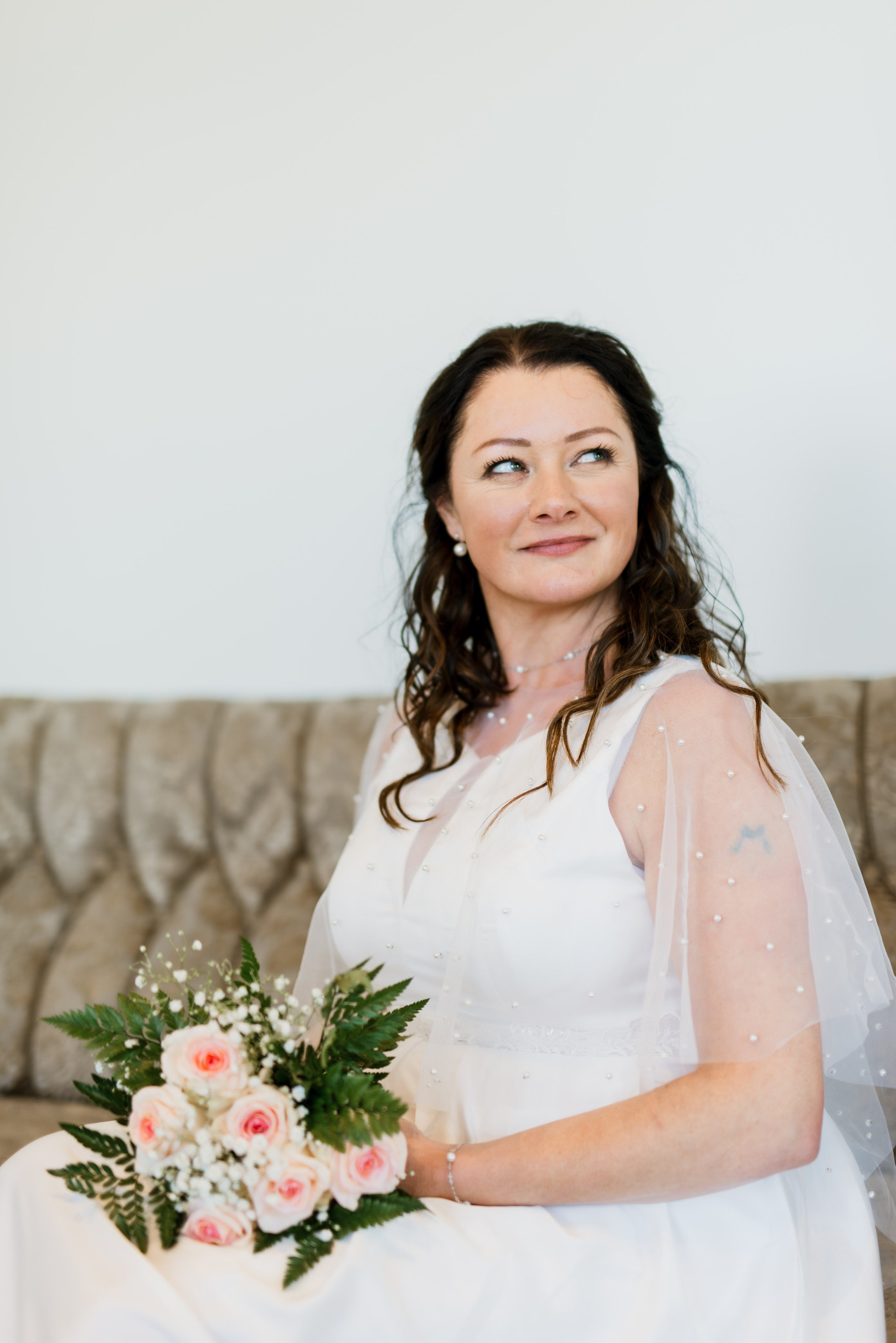 Bride in her wedding dress walking through the rustic halls of Hotel Búðir, the soft lighting creating a dreamy atmosphere.
