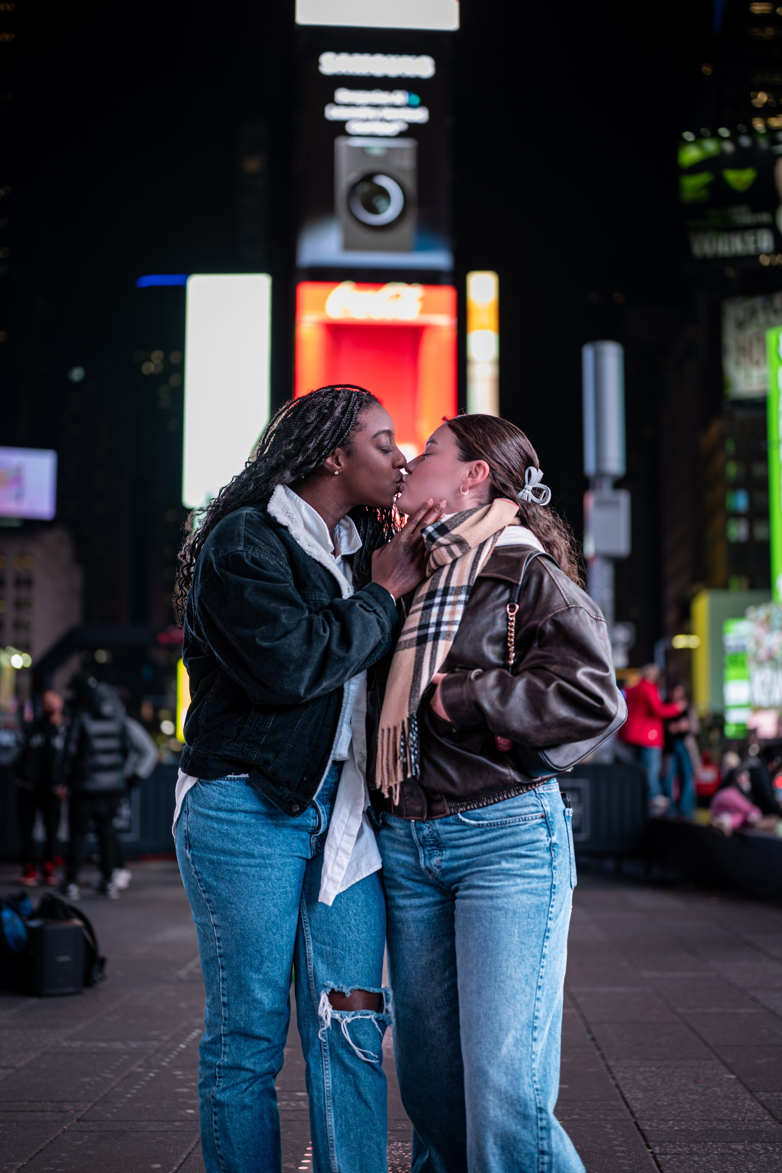 Couple kissing in Times Square at night, NYC street portrait with neon lights and bokeh.
