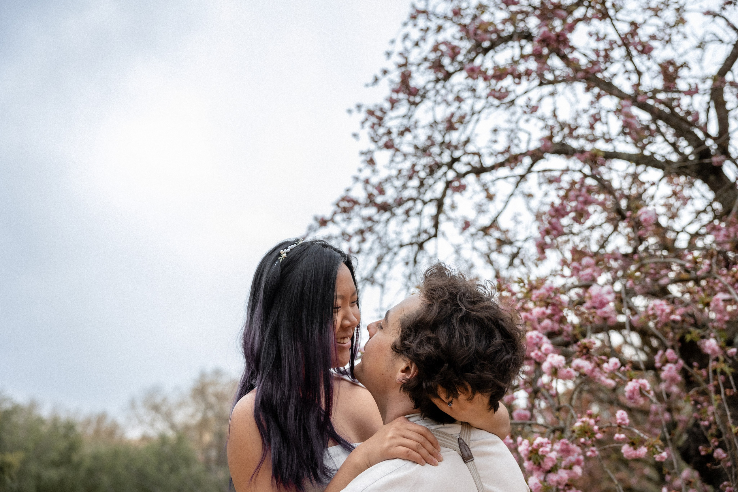 Couple beneath spring blossom trees in Toulouse, Southwest France wedding