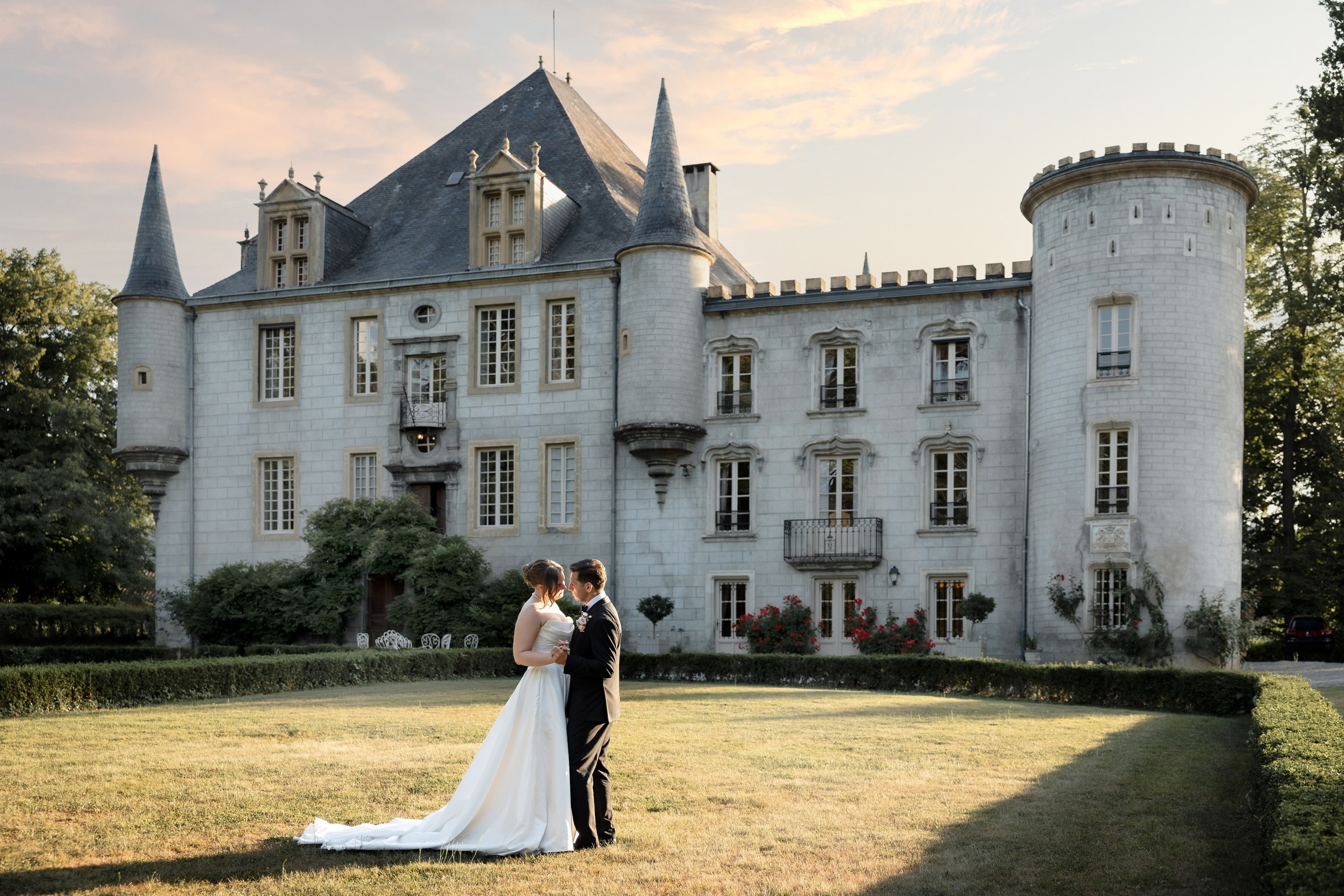 Couple embracing before Château Bagen at golden hour, Southwest France wedding
