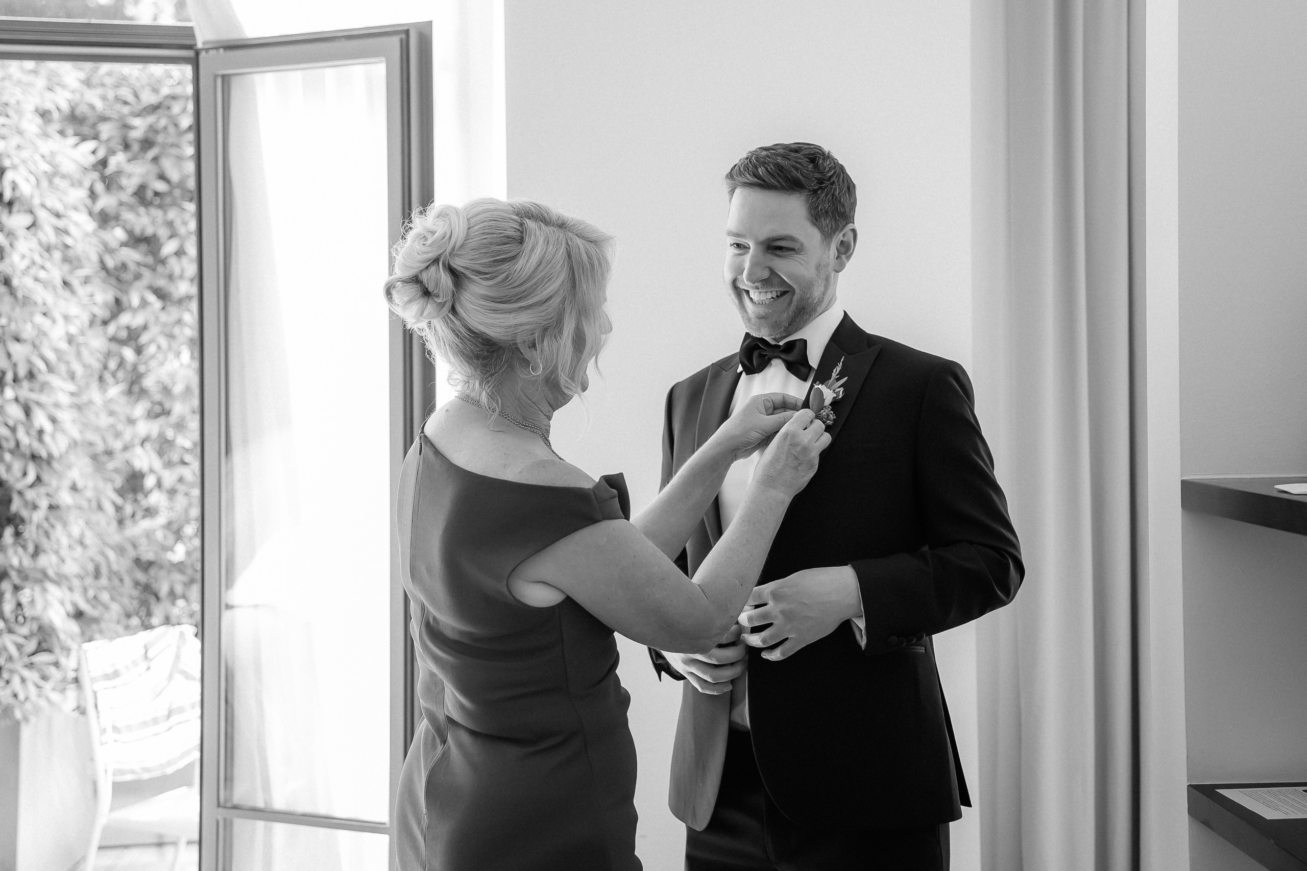 Groom helping the bride with her earrings before their Lake Como wedding at Villa Lario, Italy