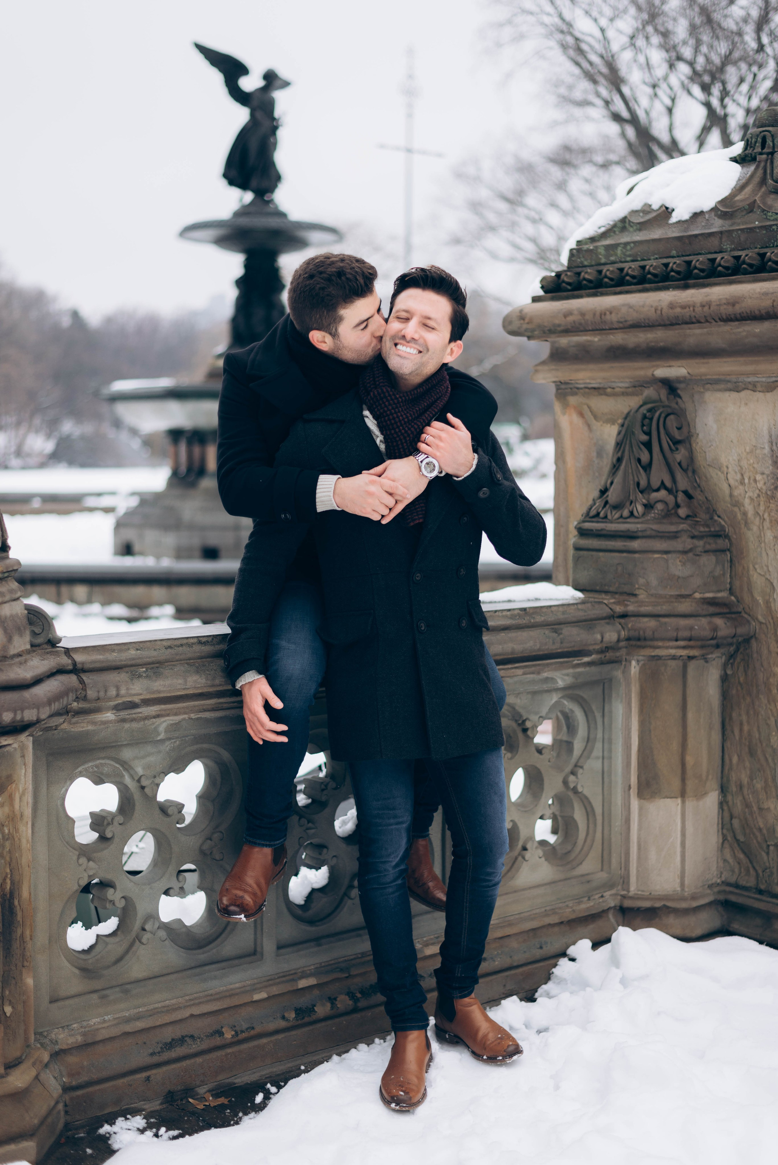 Couple celebrating proposal in Dumbo waterfront sunset.