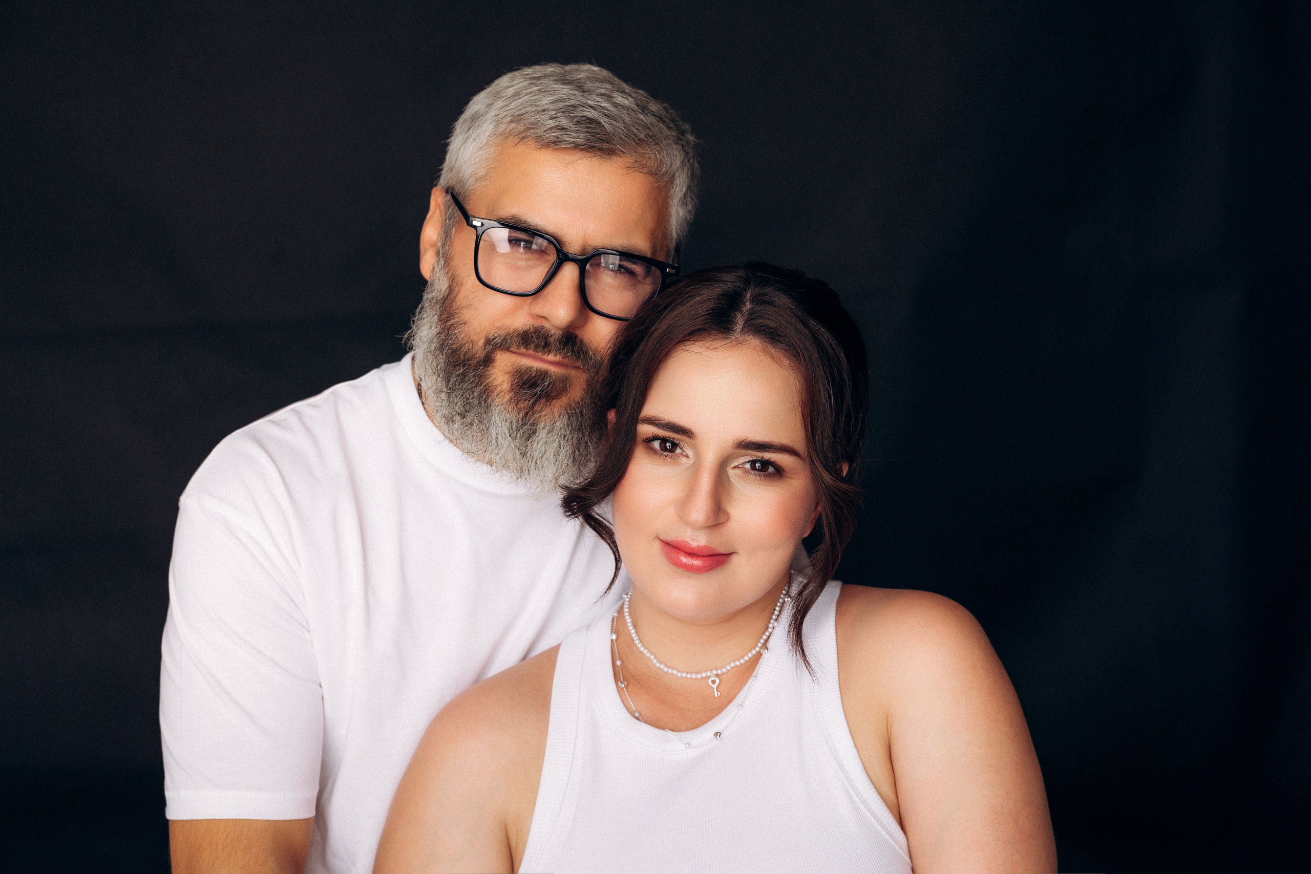 Sesja ciążowa dla par w studio Prostir – przyszli rodzice w objęciach, minimalistyczna stylizacja i emocjonalne spojrzenie.