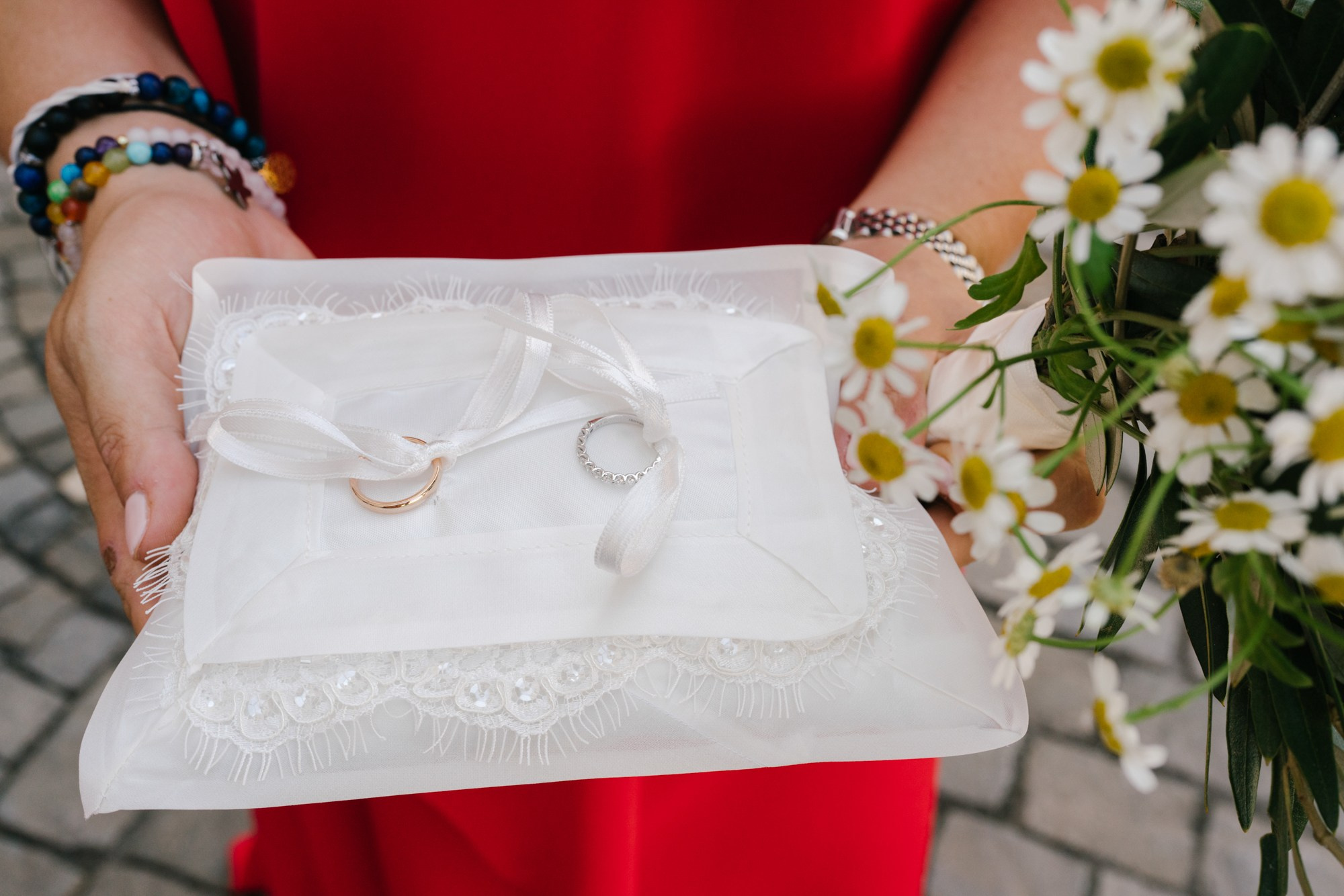 rings on pillow and flowers close by 
