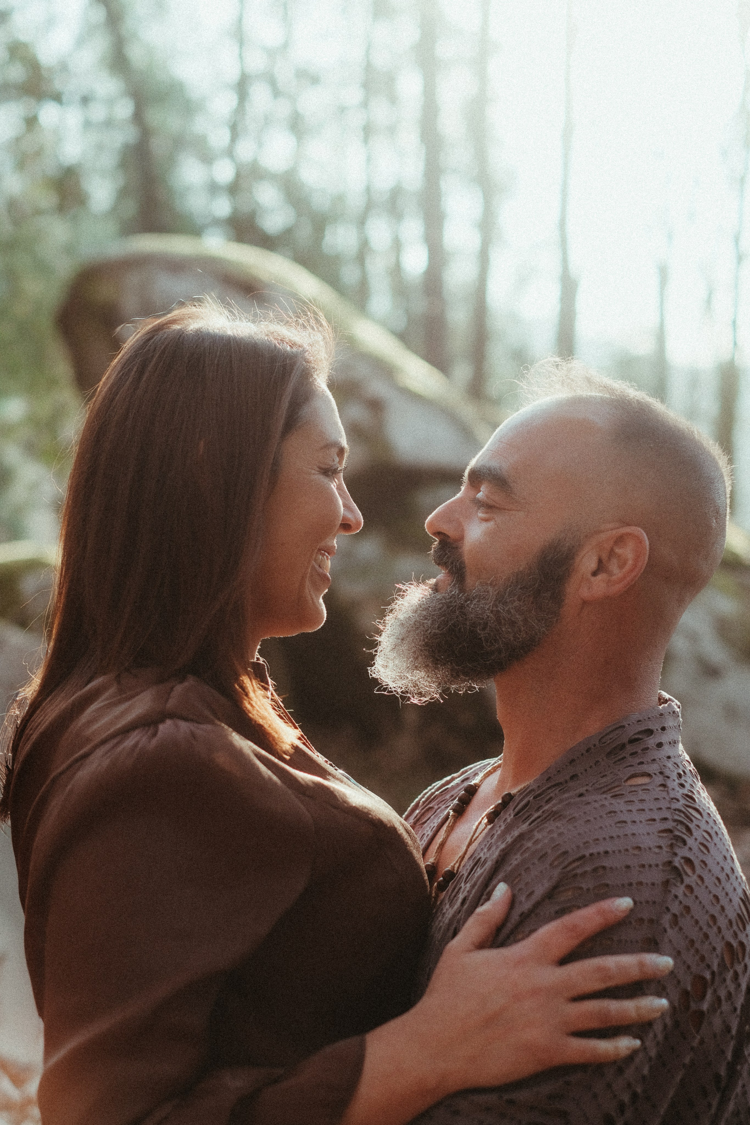 Couple on mossy rock during forest engagement session in Portugal