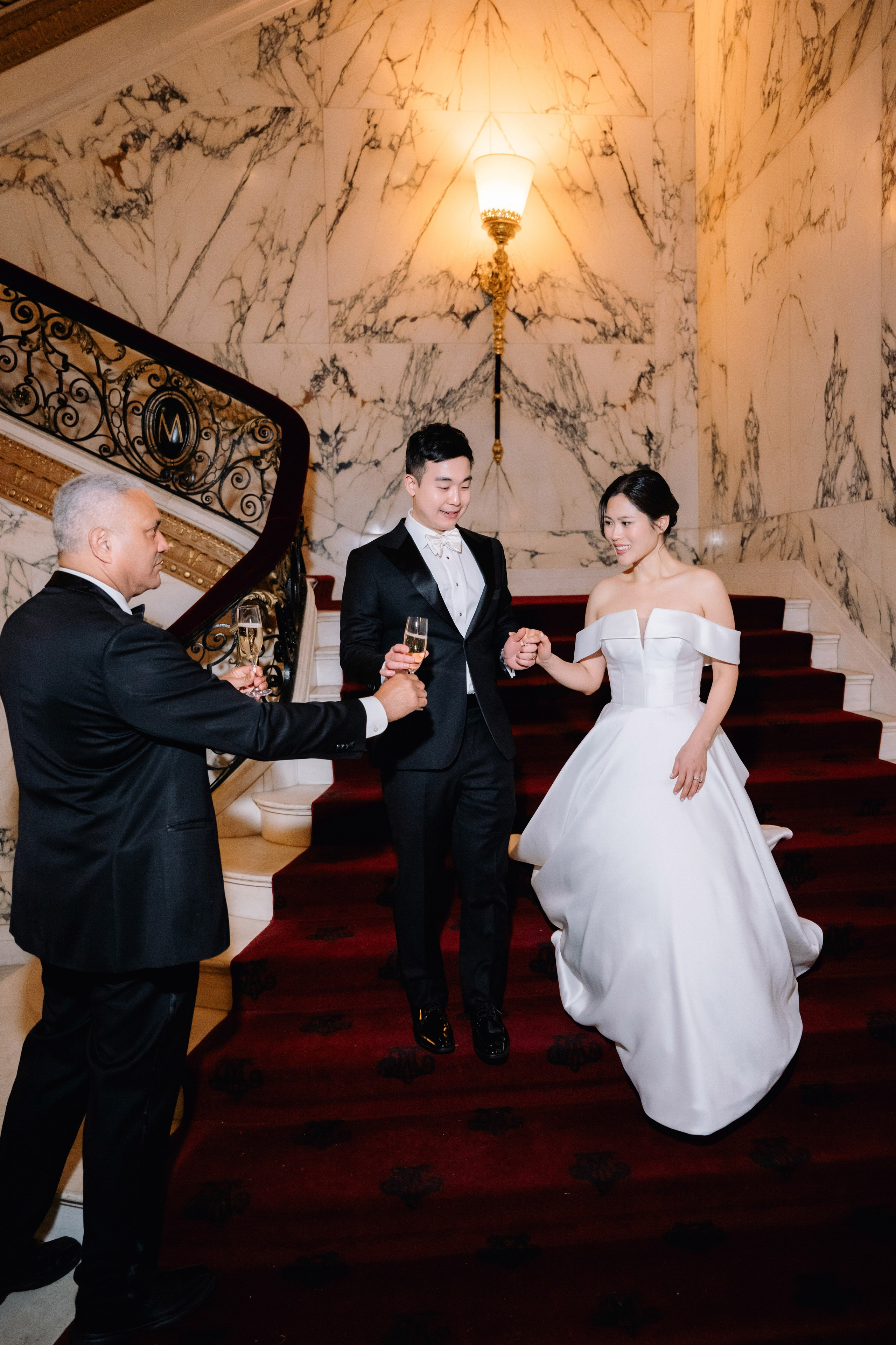 a man and woman in formal attire standing on a staircase
