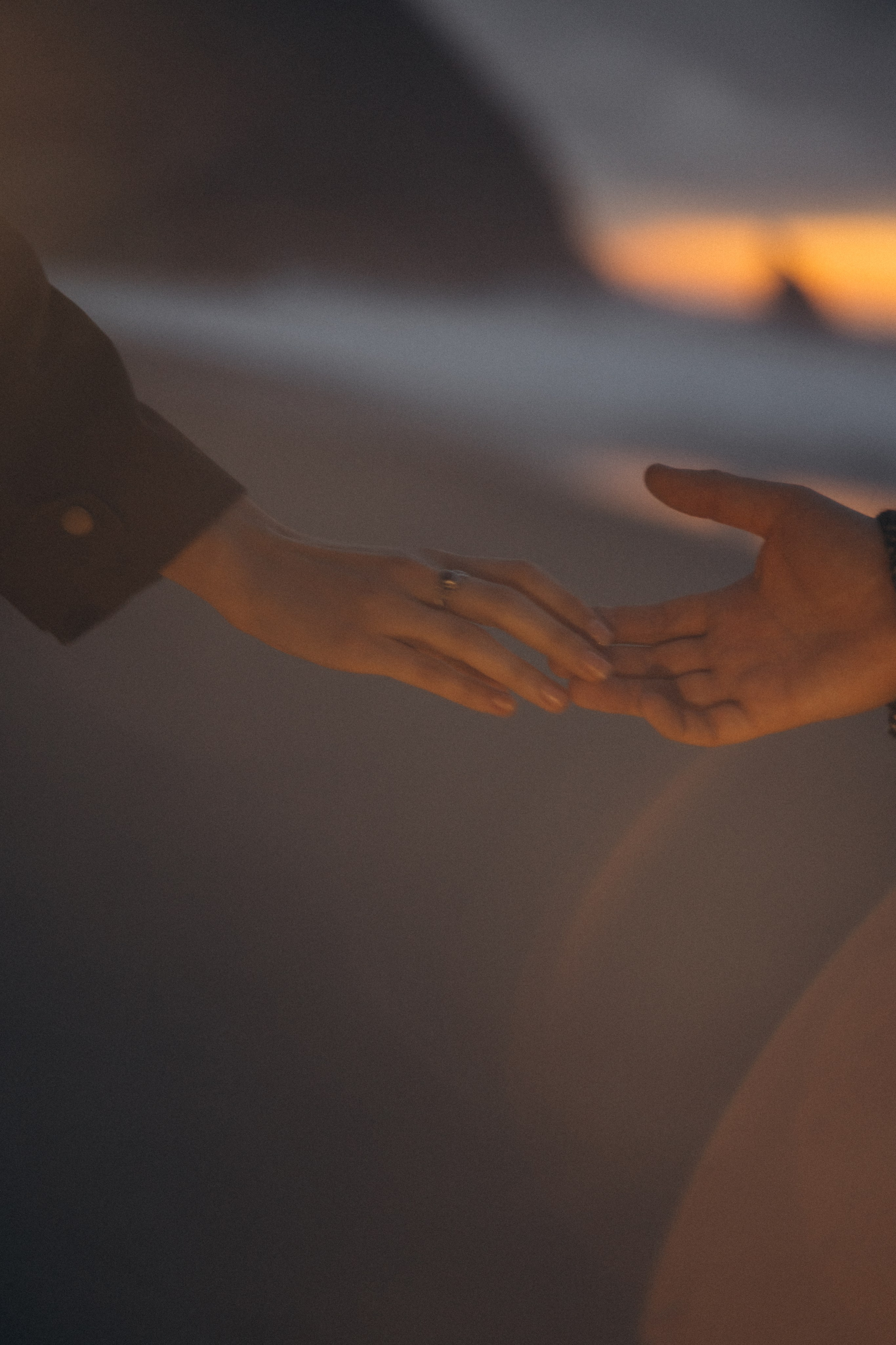 Couple holding hands and walking through a picturesque coastline in Portugal.