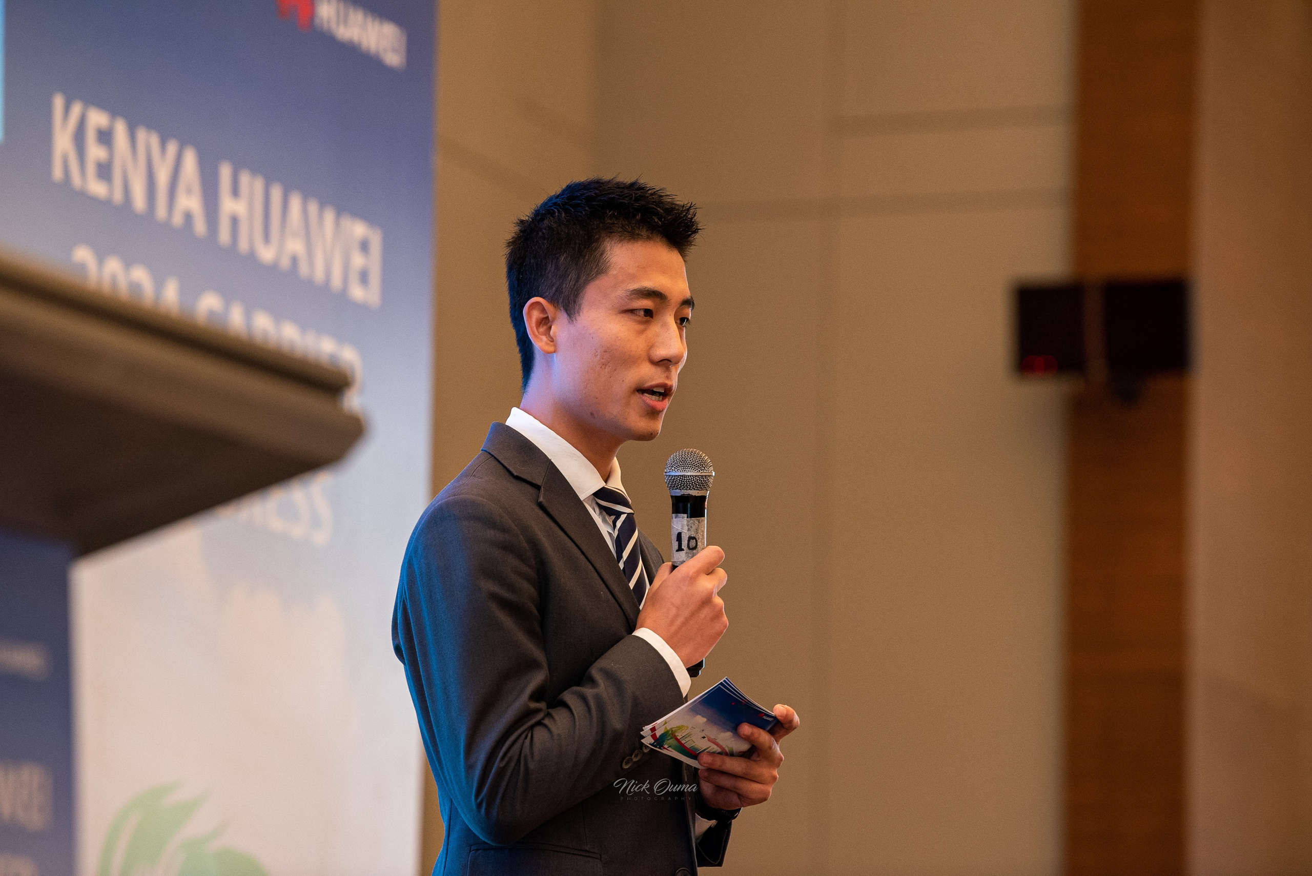 A close-up portrait of a Huawei executive giving a speech at a corporate event held at Hyatt Regency in Nairobi.