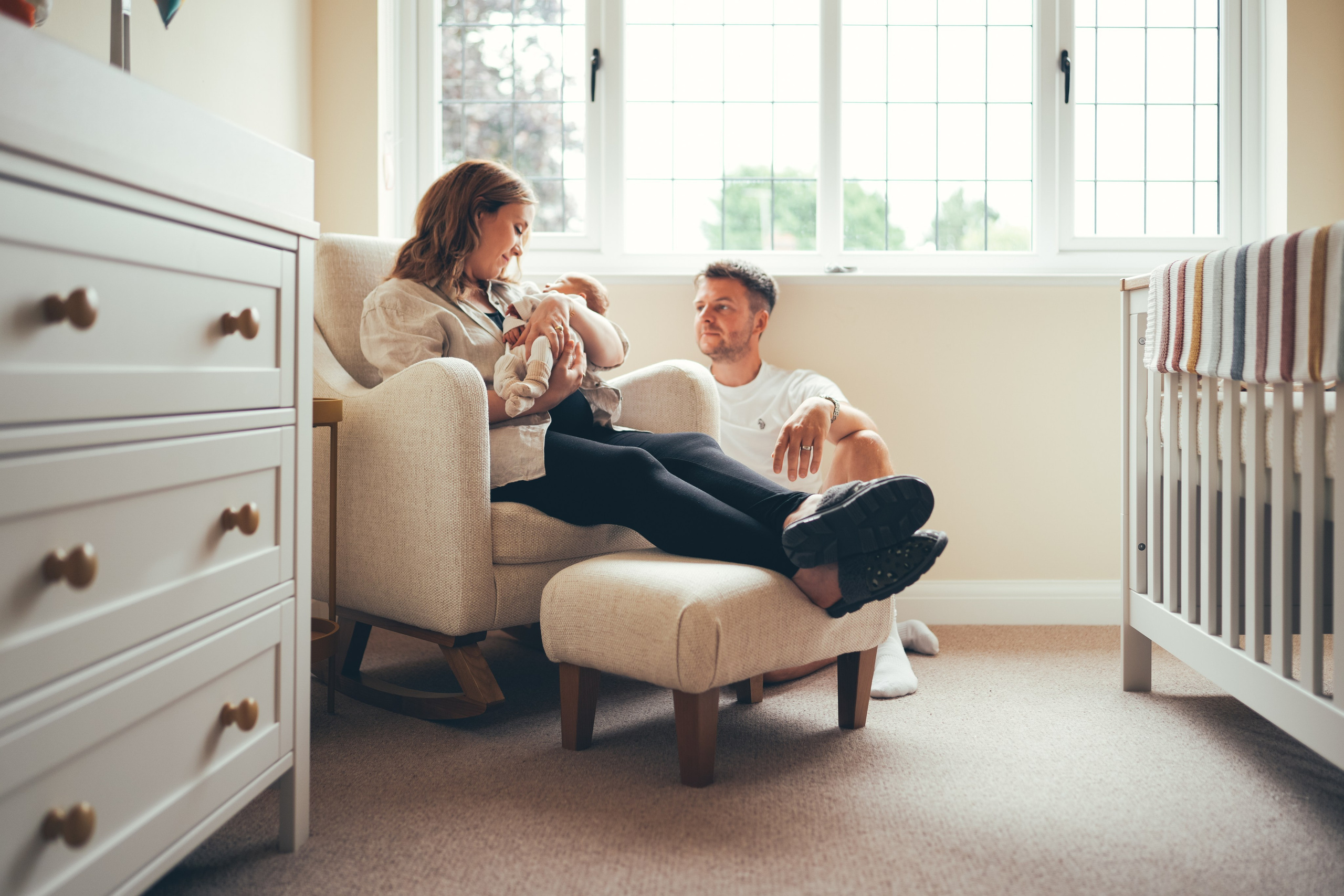 Parents with their newborn baby at home captured in a natural newborn photography session in Solihull.