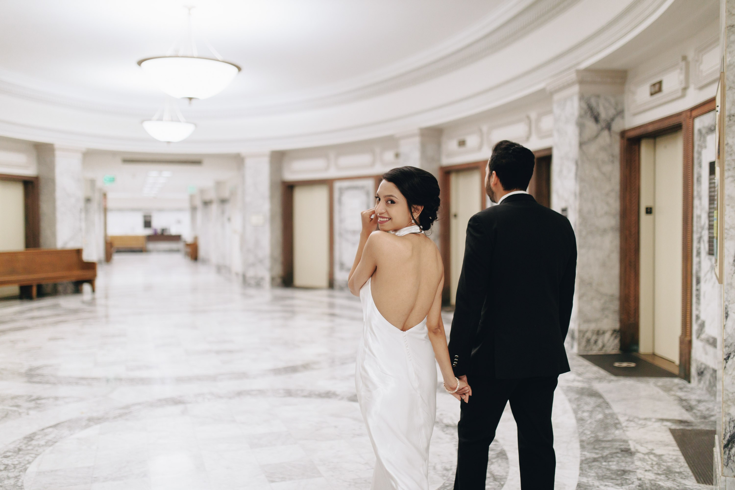 Bride and groom walking in elegant marble hallway