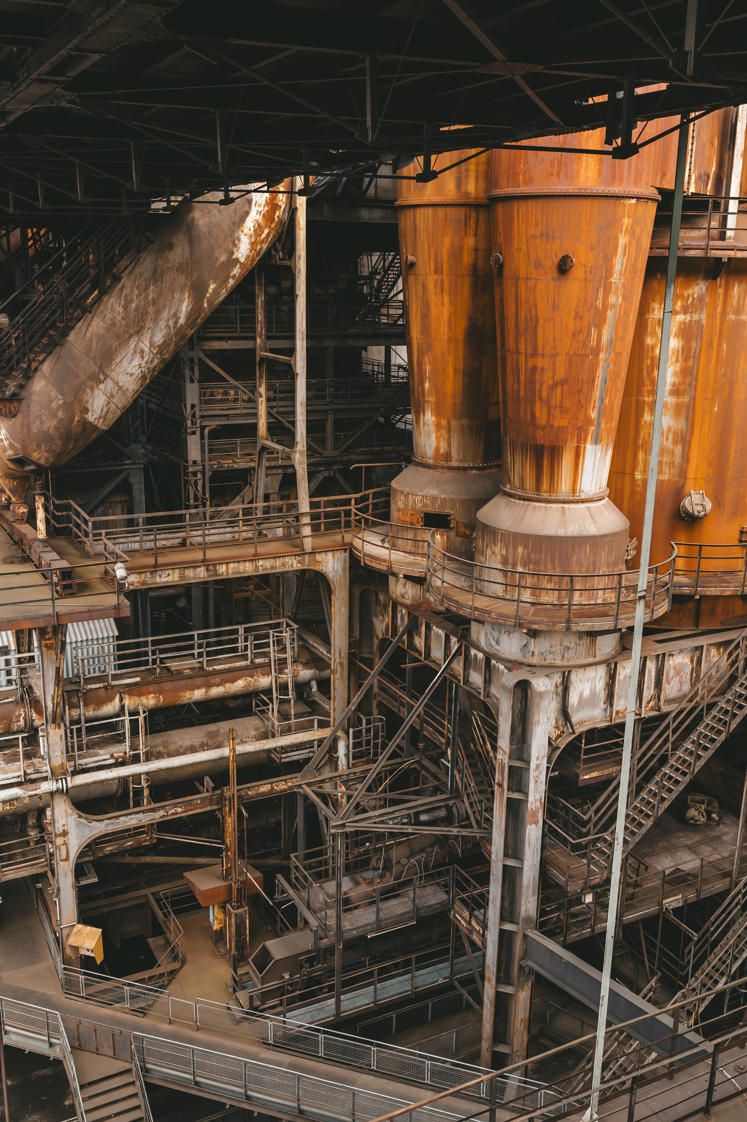 Внутренний вид производственного корпуса с лестницами и металлическими трубами.