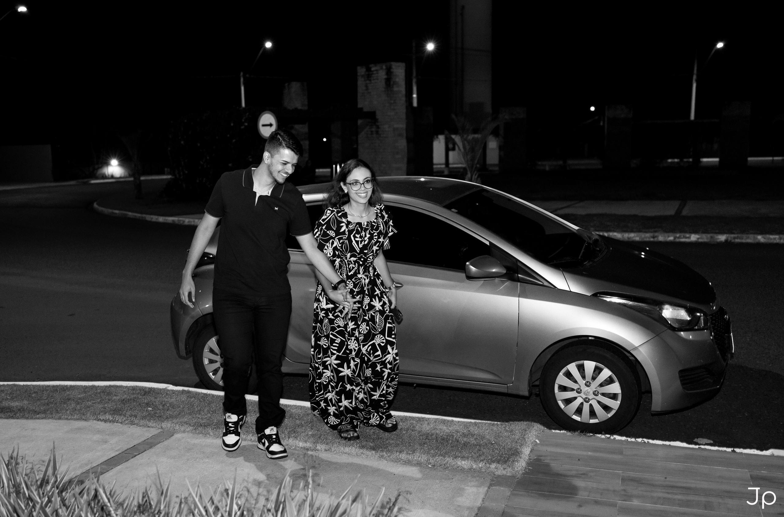 Casal saindo juntos do carro à noite em Agudos