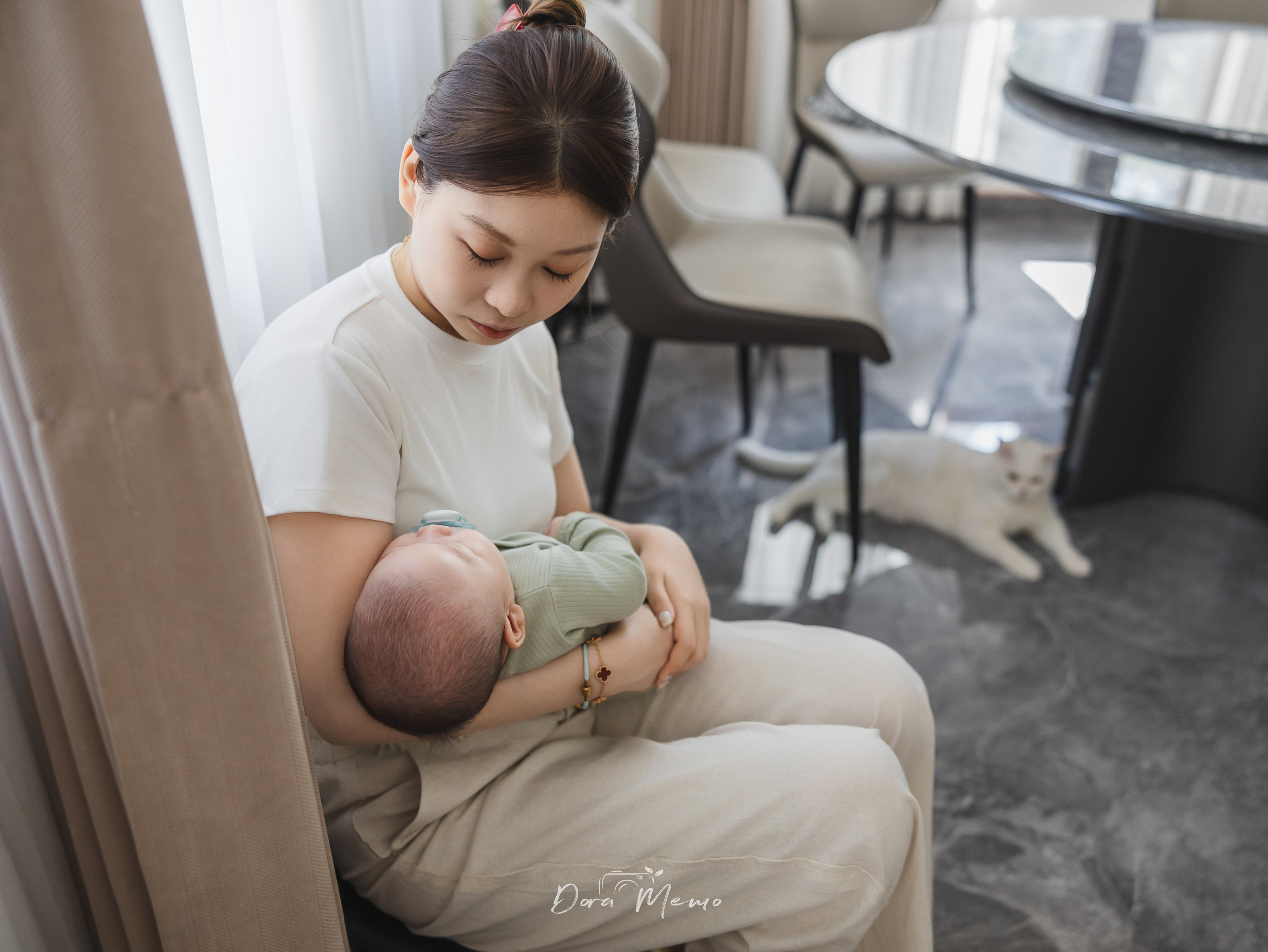 Through the cat's eyes — a quiet scene of a mother holding her baby at home |