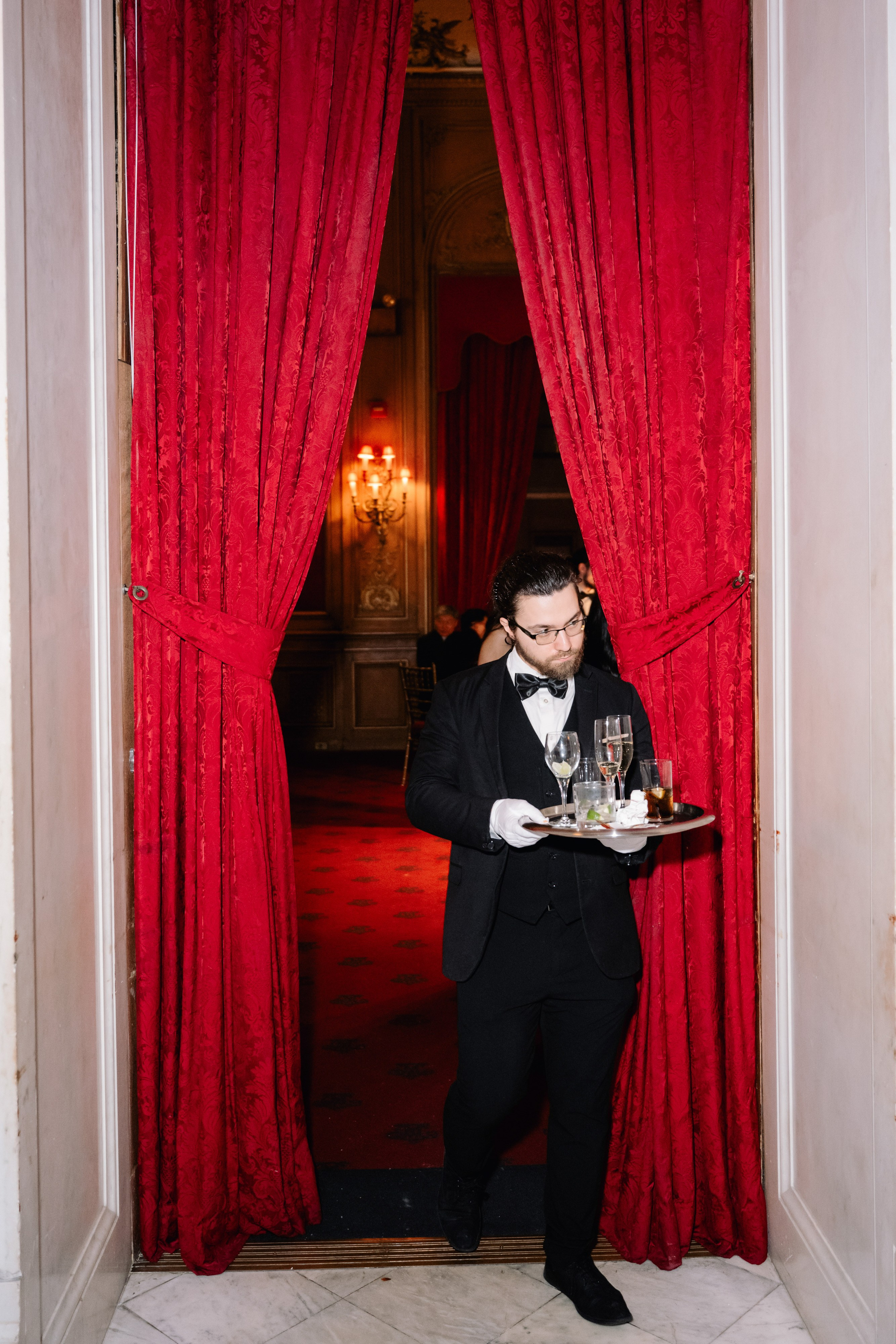 a man in a tuxed suit holding a tray of food