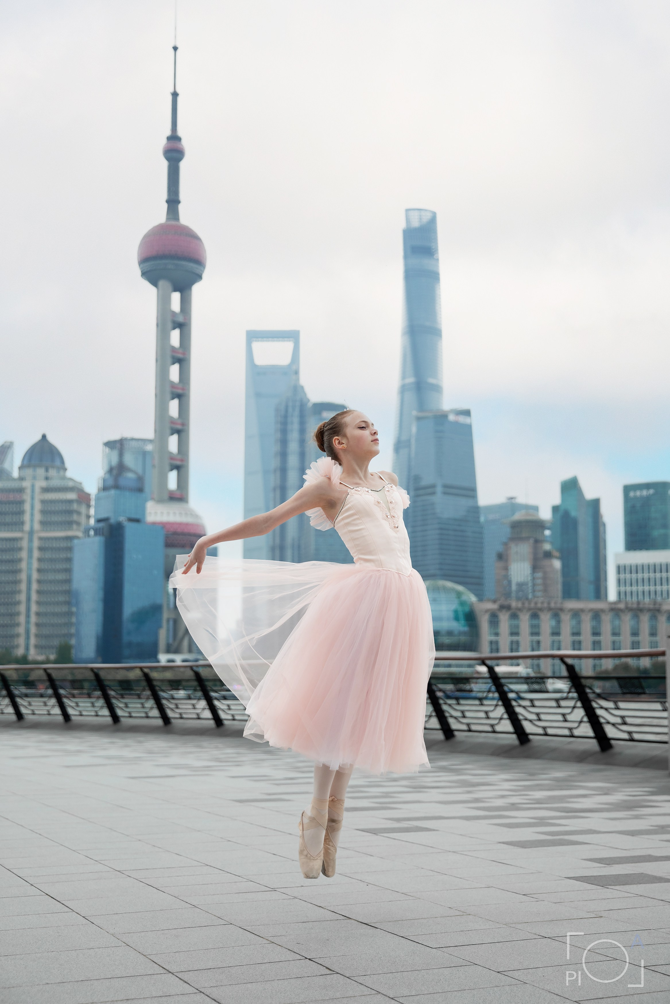 Фотосессия в Шанхае для девочки 11 лет. Маленькая балерина в розовом платье с пышной длинной пачкой, танцует на набережной в Шанхае с видом на Lujiazui