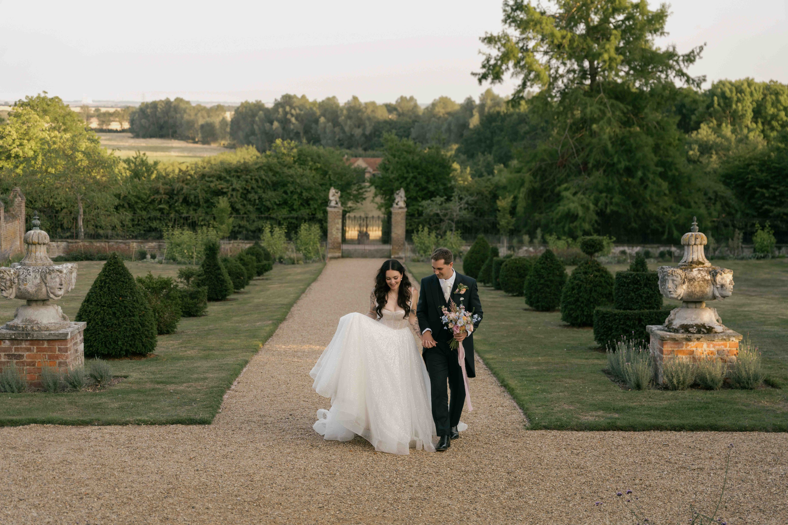     newlyweds walking in gardens Layer Marney Tower summer wedding