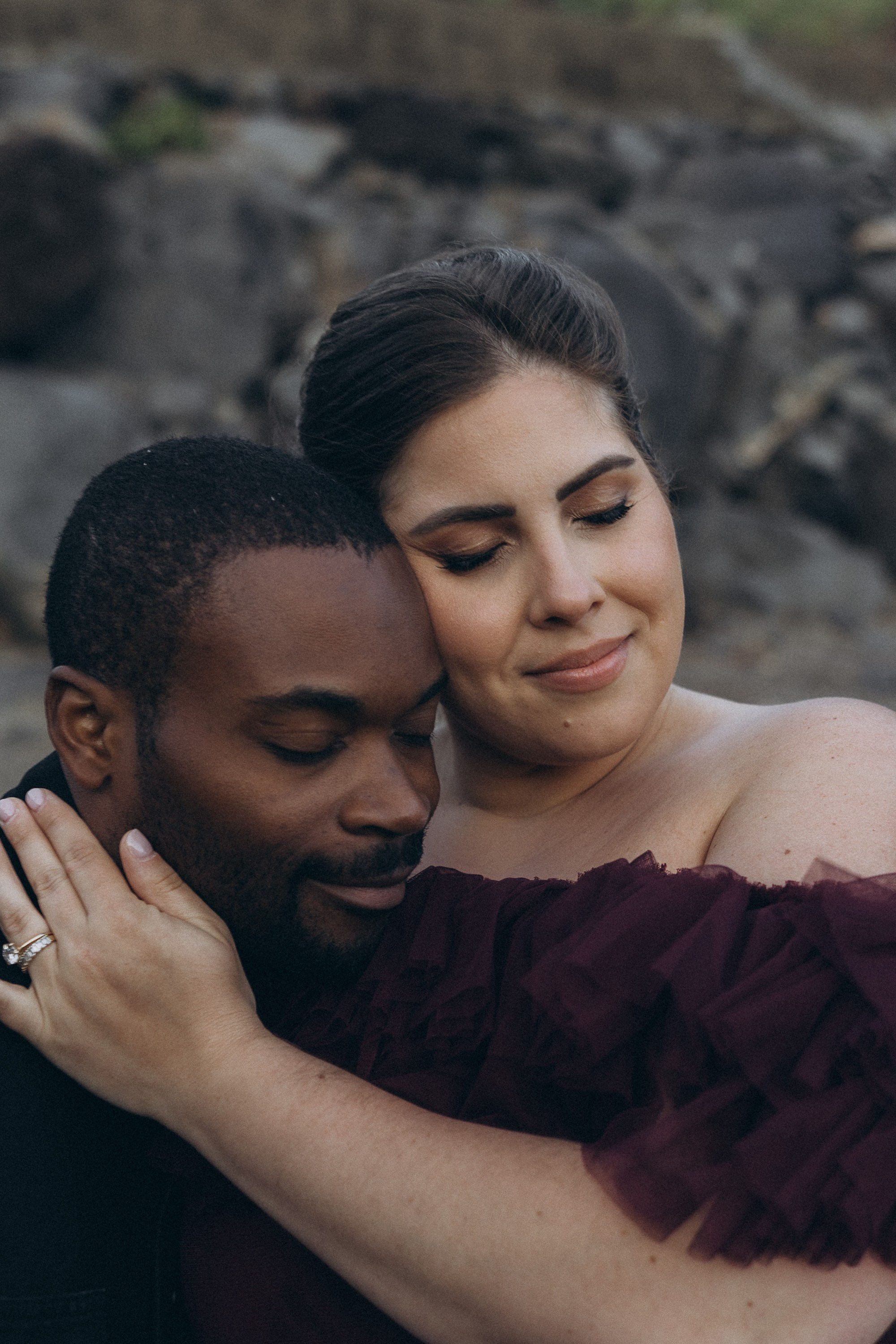 A glowing expectant mother standing on a cliff overlooking the ocean in Madeira, her dress flowing gently in the wind as the golden sunset casts a warm glow.