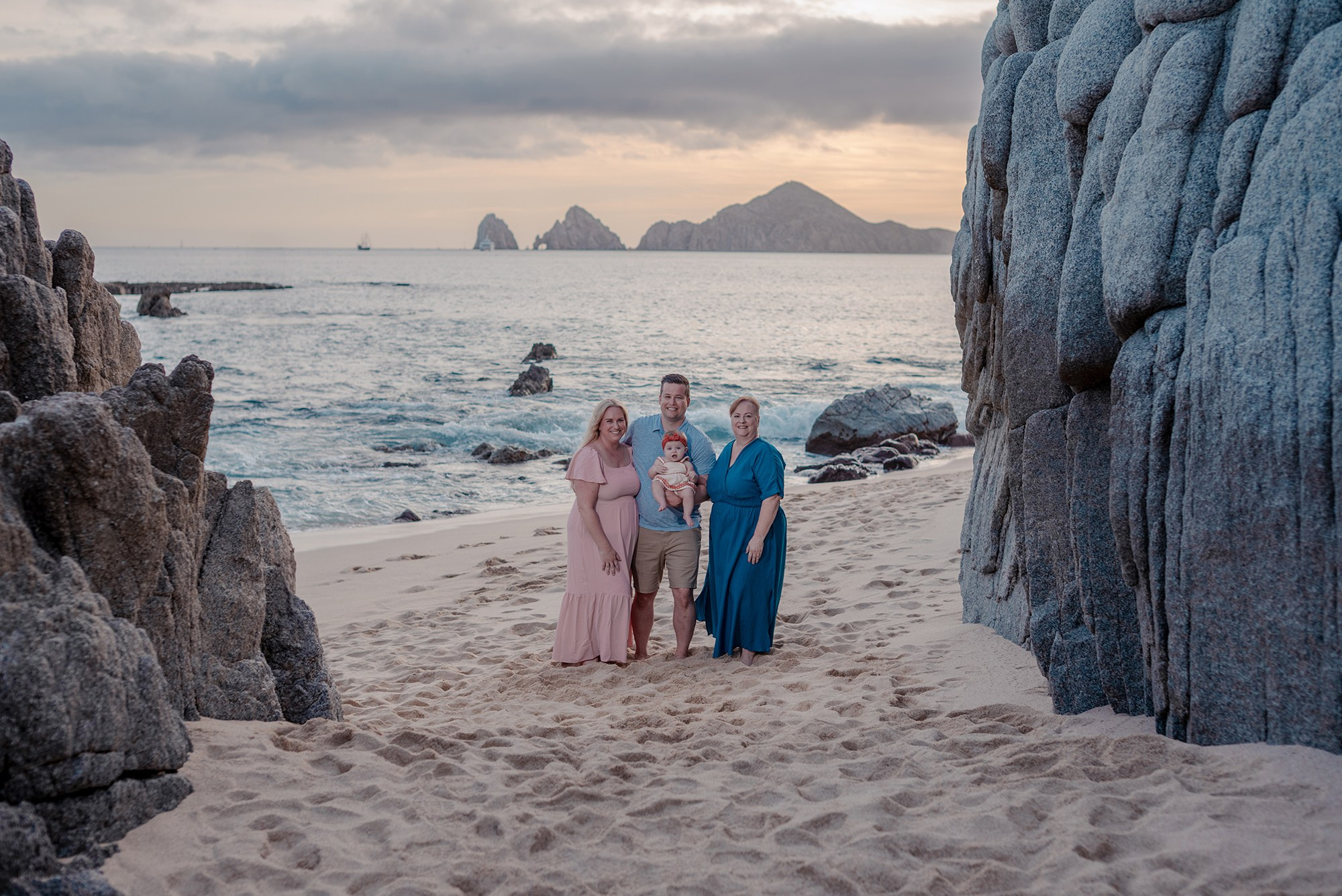 Parents with baby during relaxed vacation photo session on the beach at Playa Monumentos Cabo San Lucas Baja California
