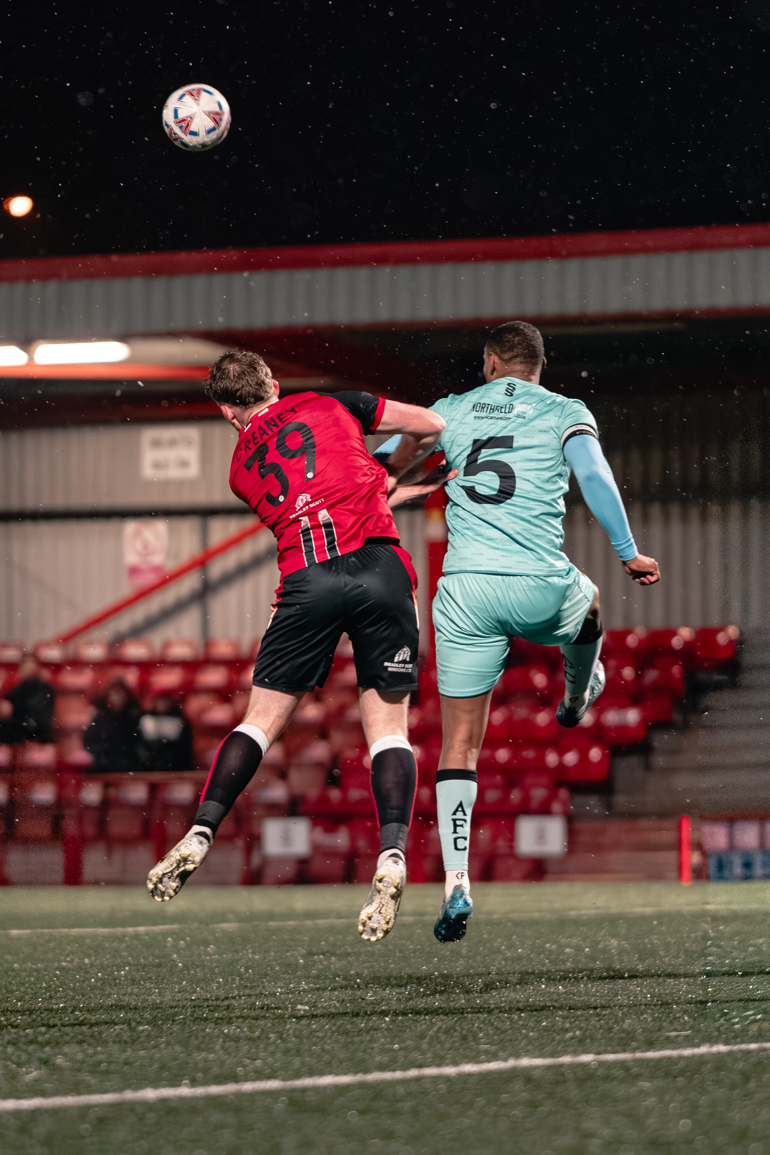 Tamworth’s Dan Creaney (39) challenges Alvechurch No.5 for an aerial ball during Birmingham Senior Cup match at The Lamb Ground, Feb 3 2026.