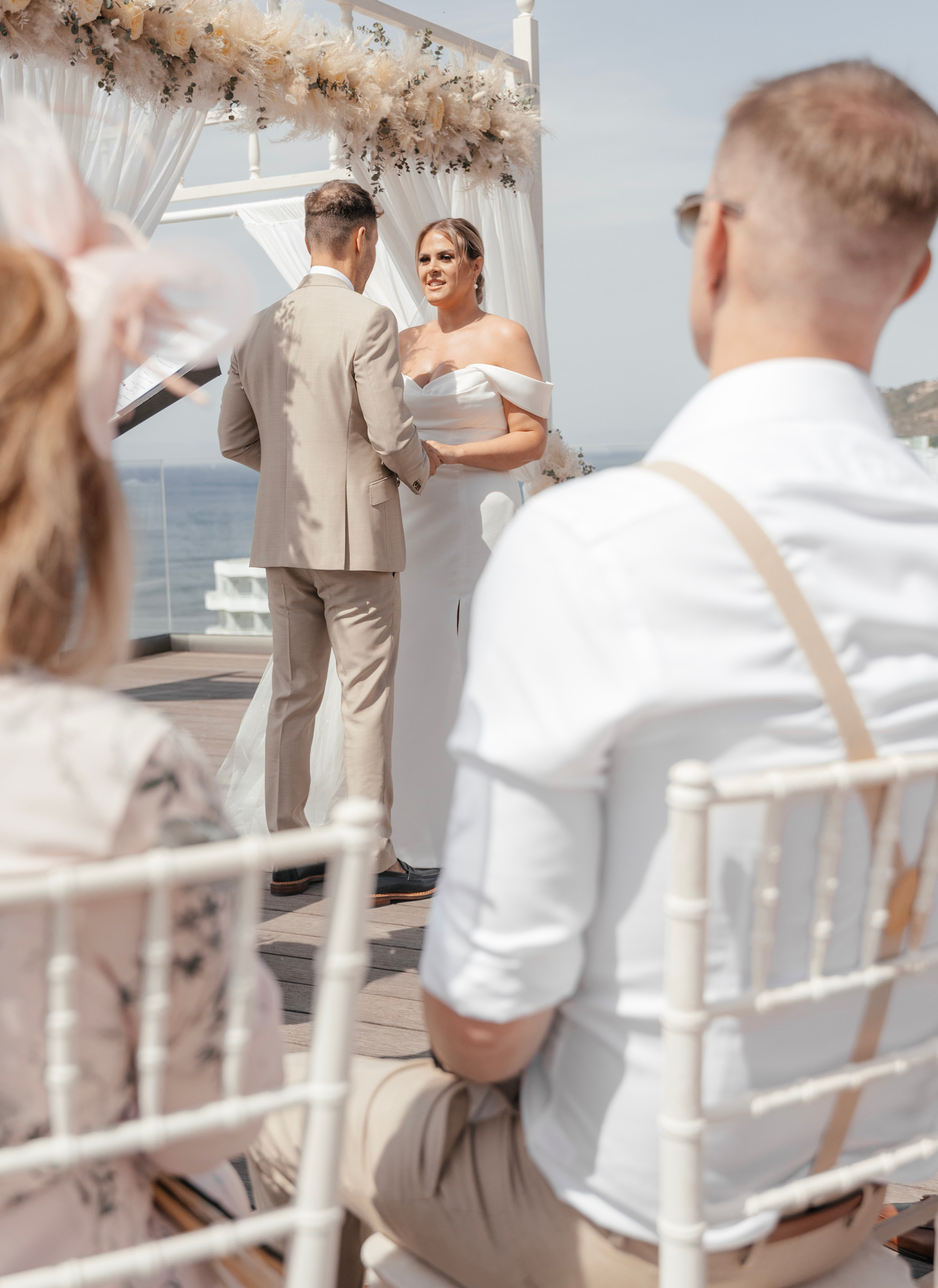 Bride and groom exchanging vows with a stunning view of the Aegean Sea in the background in Sheraton hotel, Greece, Rhodes