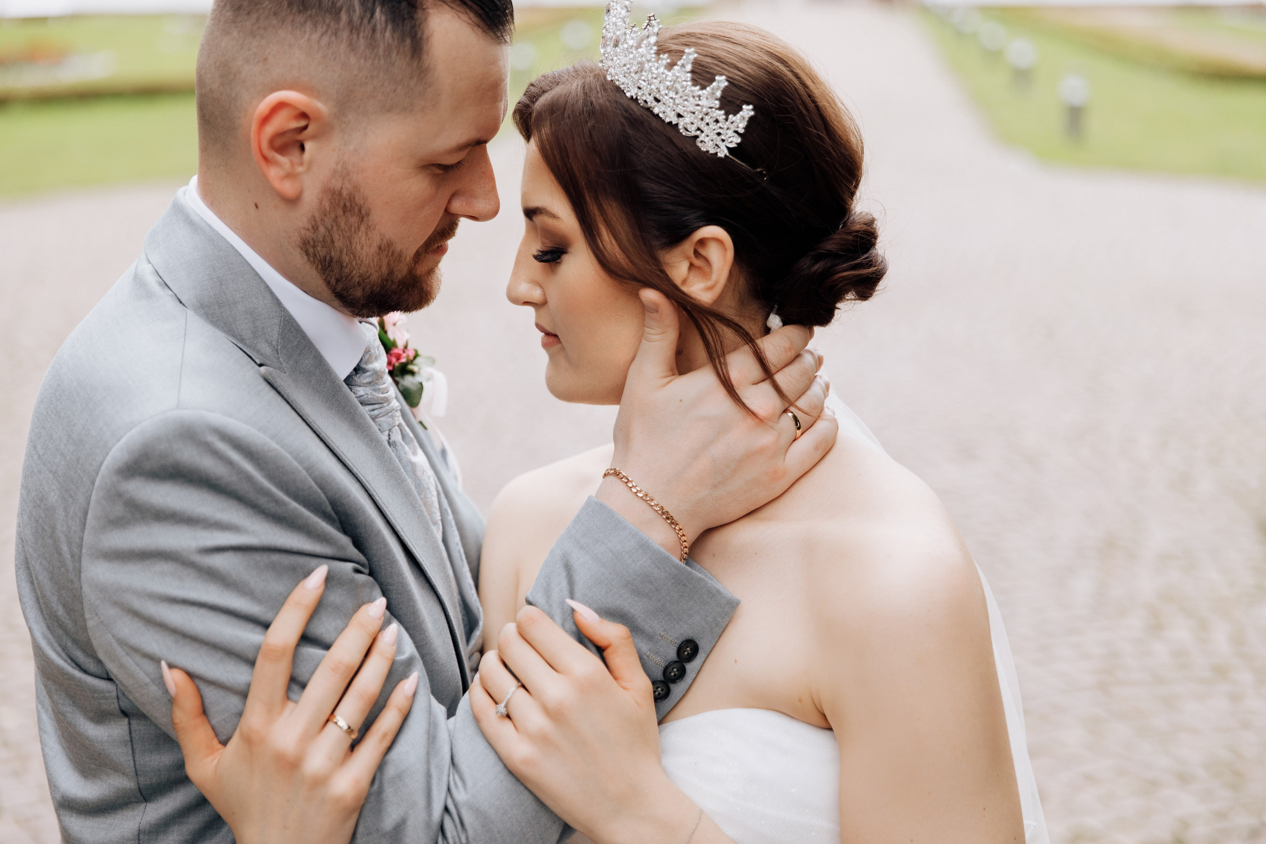 Der Bräutigam und die Braut umarmen sich und schließen dabei die Augen. 