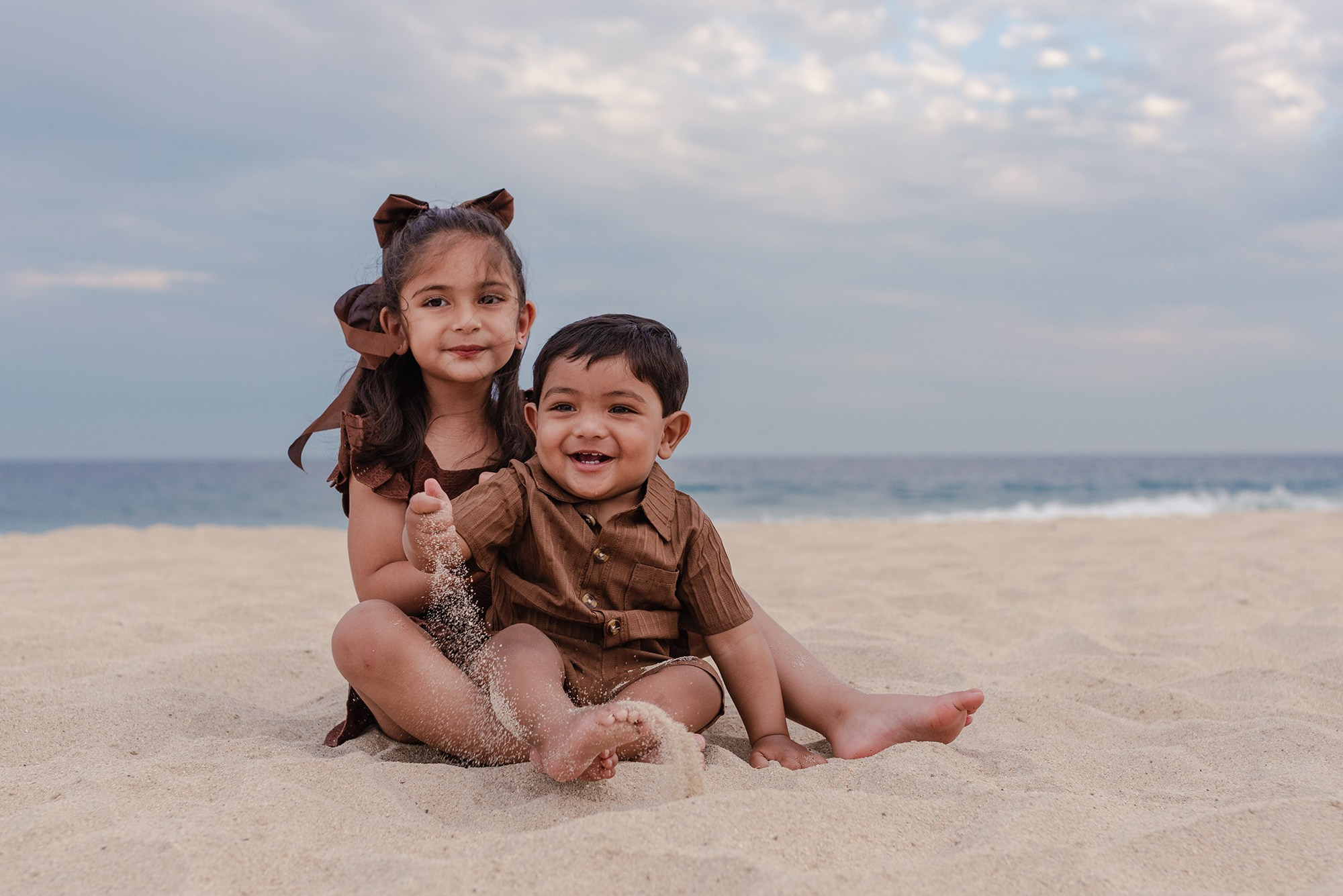 Brother and sister sitting together on the beach at Hyatt Ziva Los Cabos
