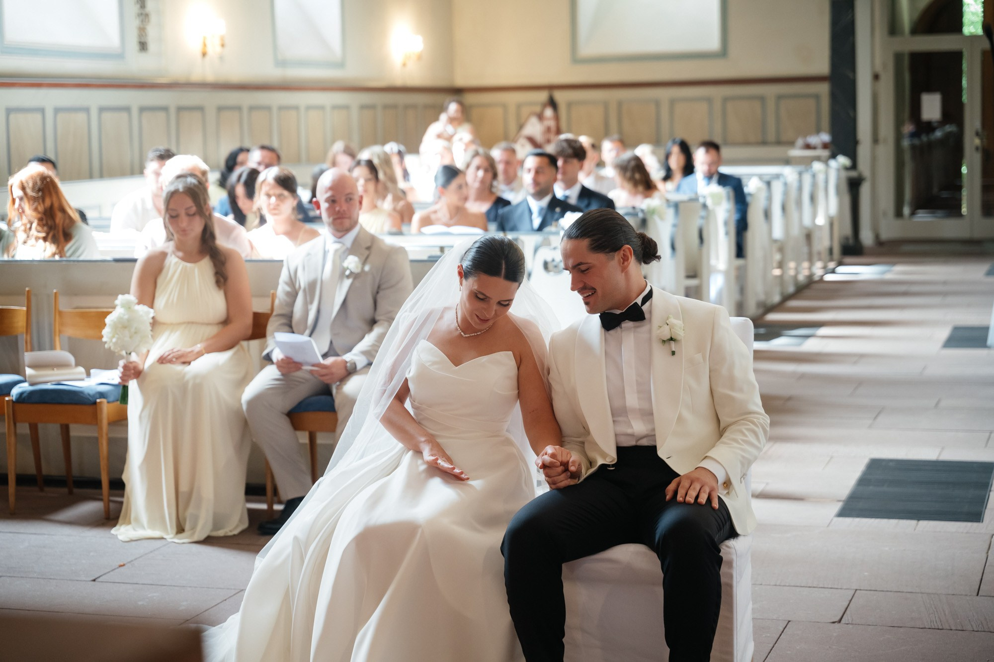 Couple laughing during the ceremony, guests in the background