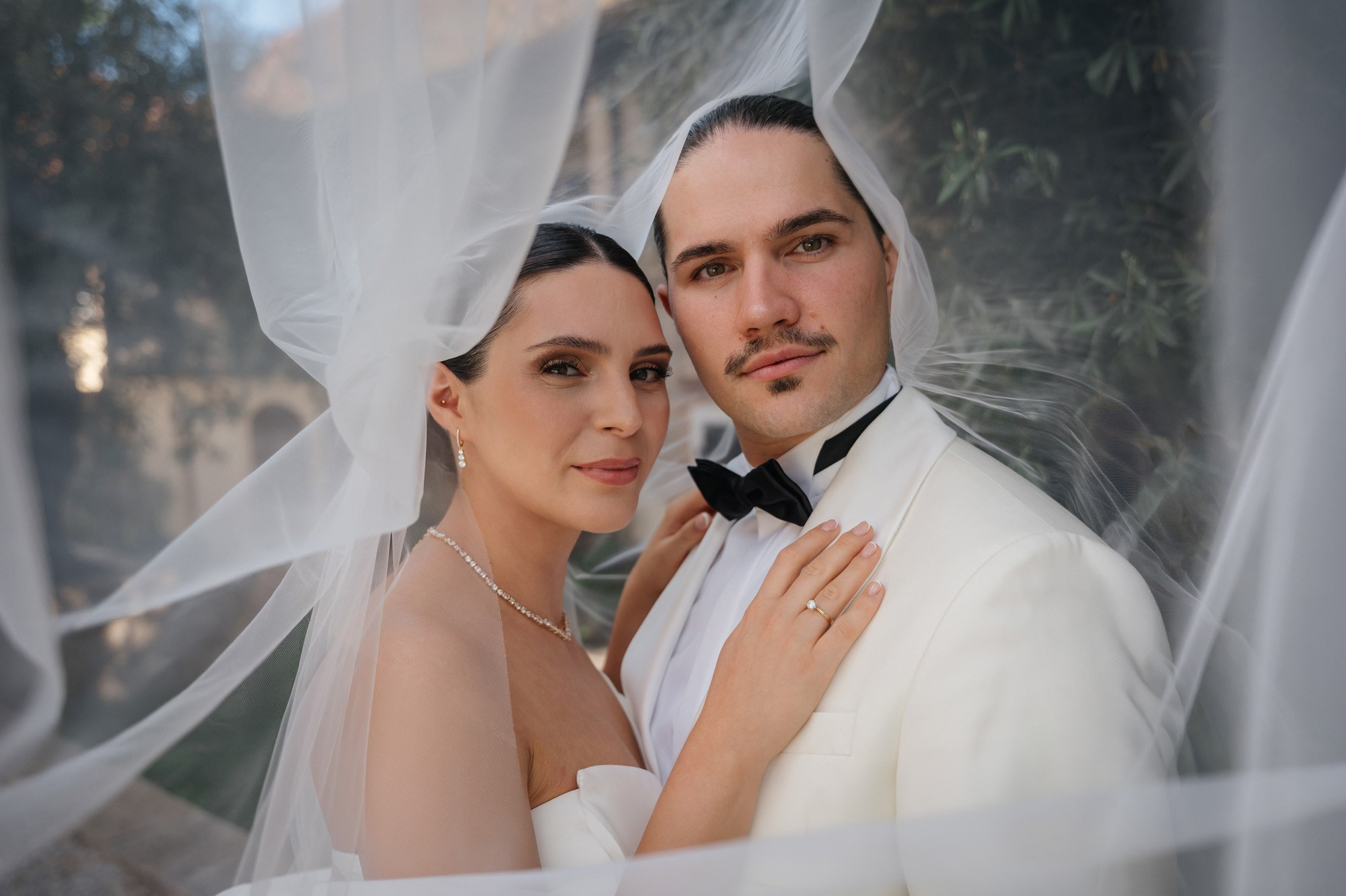 Portrait of the couple under the bridal veil
