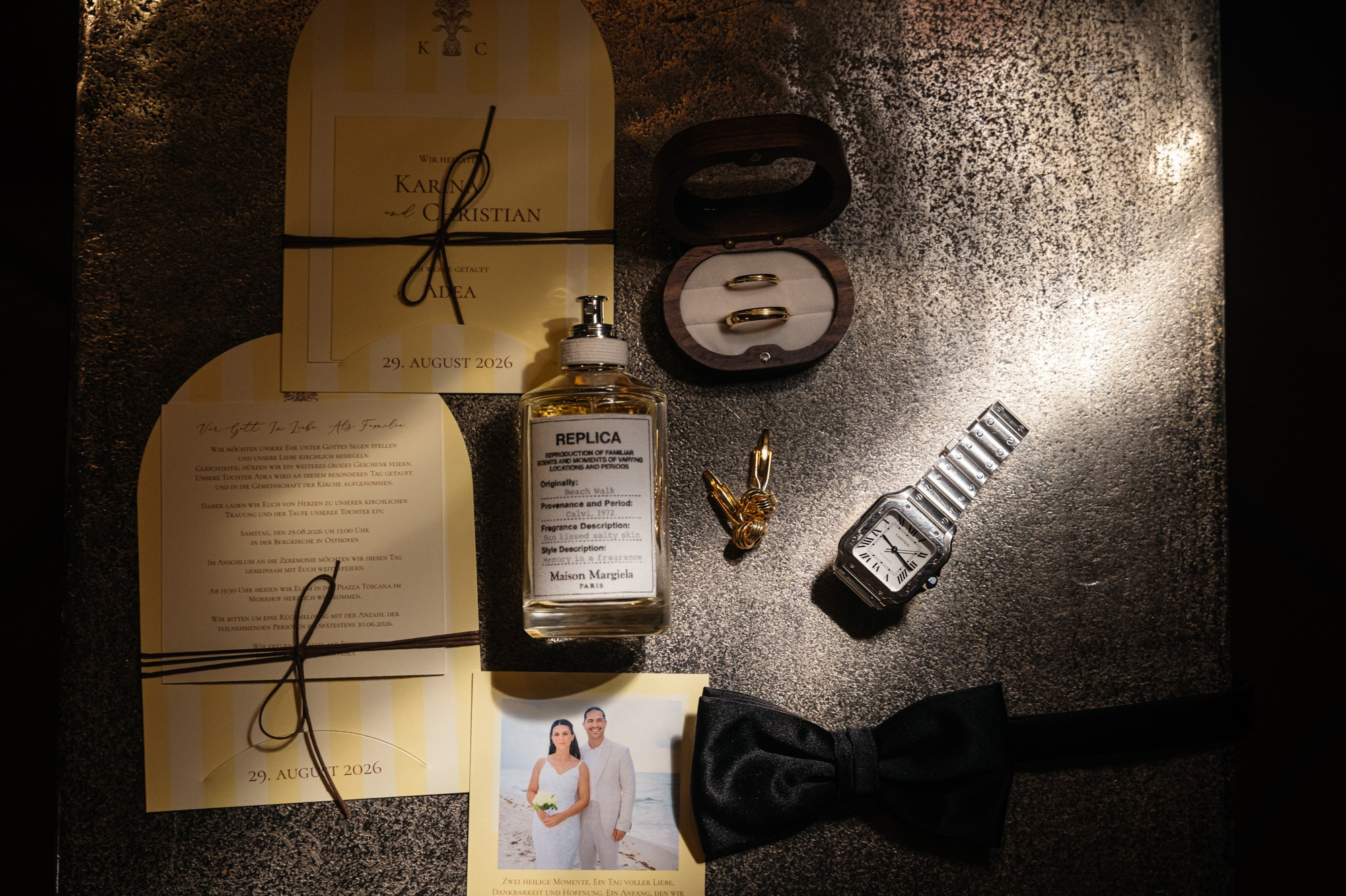 Wedding invitation, perfume, watch and bow tie in a getting ready detail shot