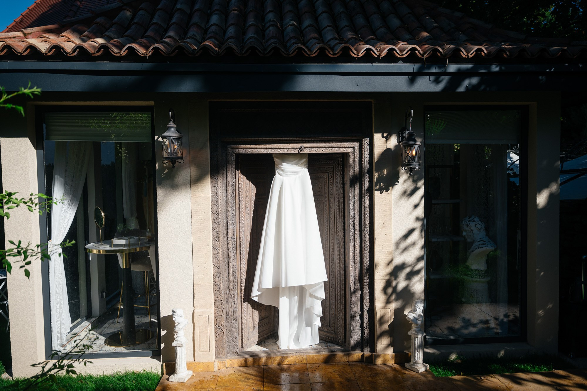 Wedding dress hanging in the doorway of a garden house at the Morrhof