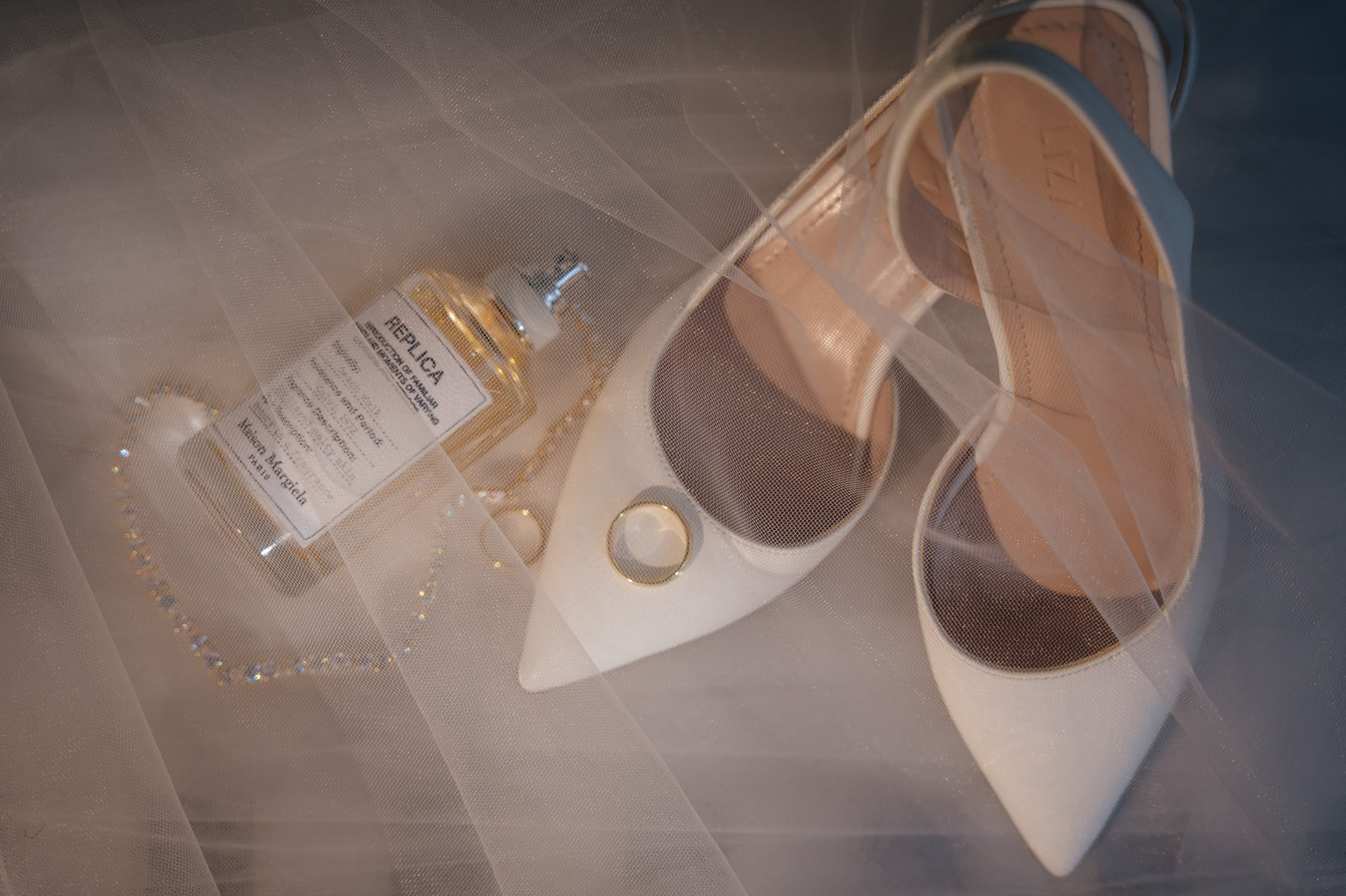 Bridal shoes, perfume and wedding rings in detail