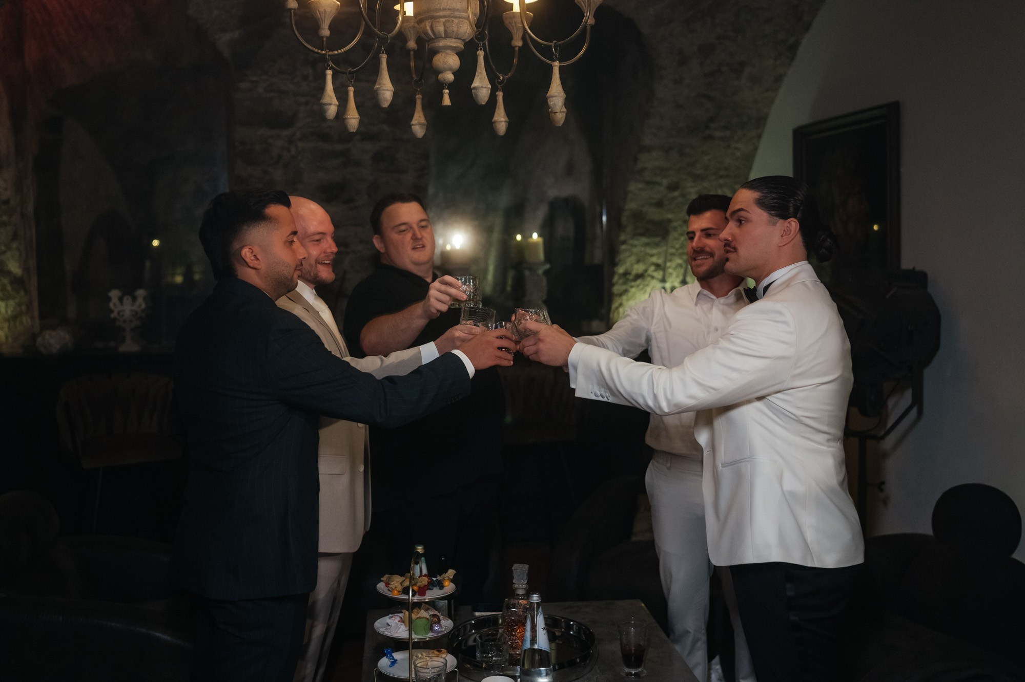 Groom raising a toast with his friends while getting ready