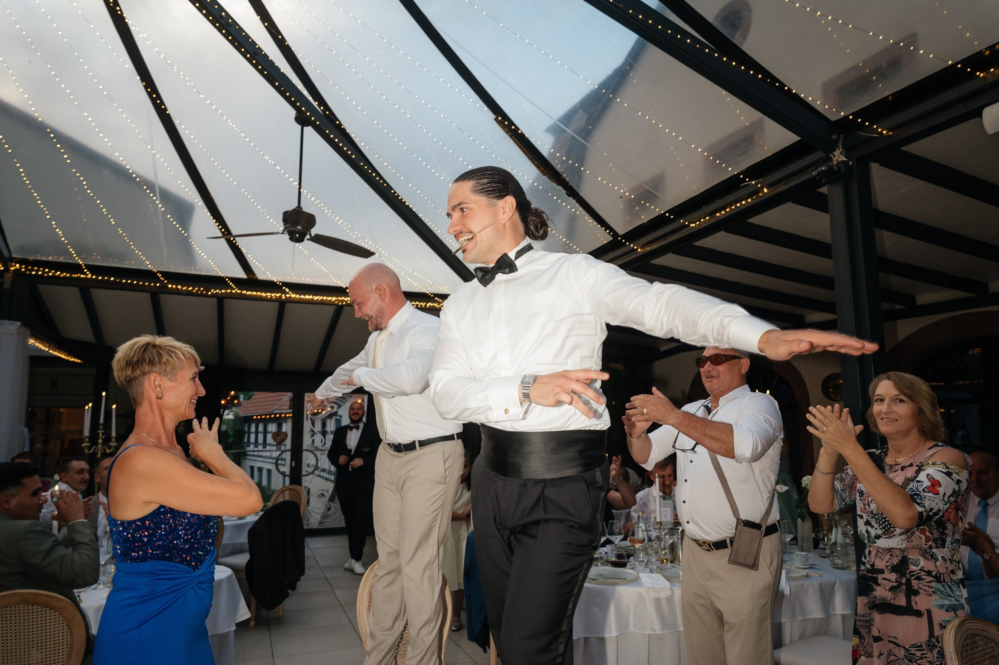 Groom celebrating with outstretched arms among the guests