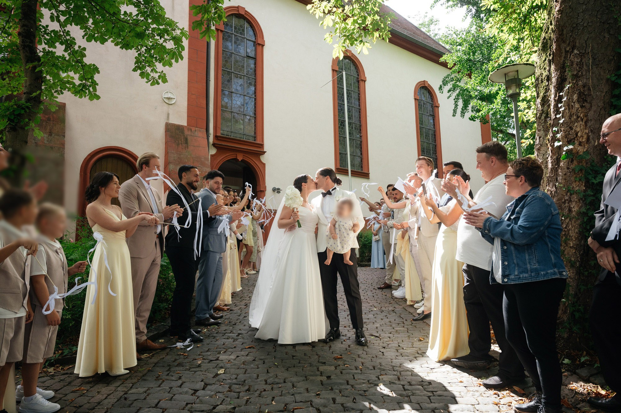 Guests applauding the newlyweds outside the church