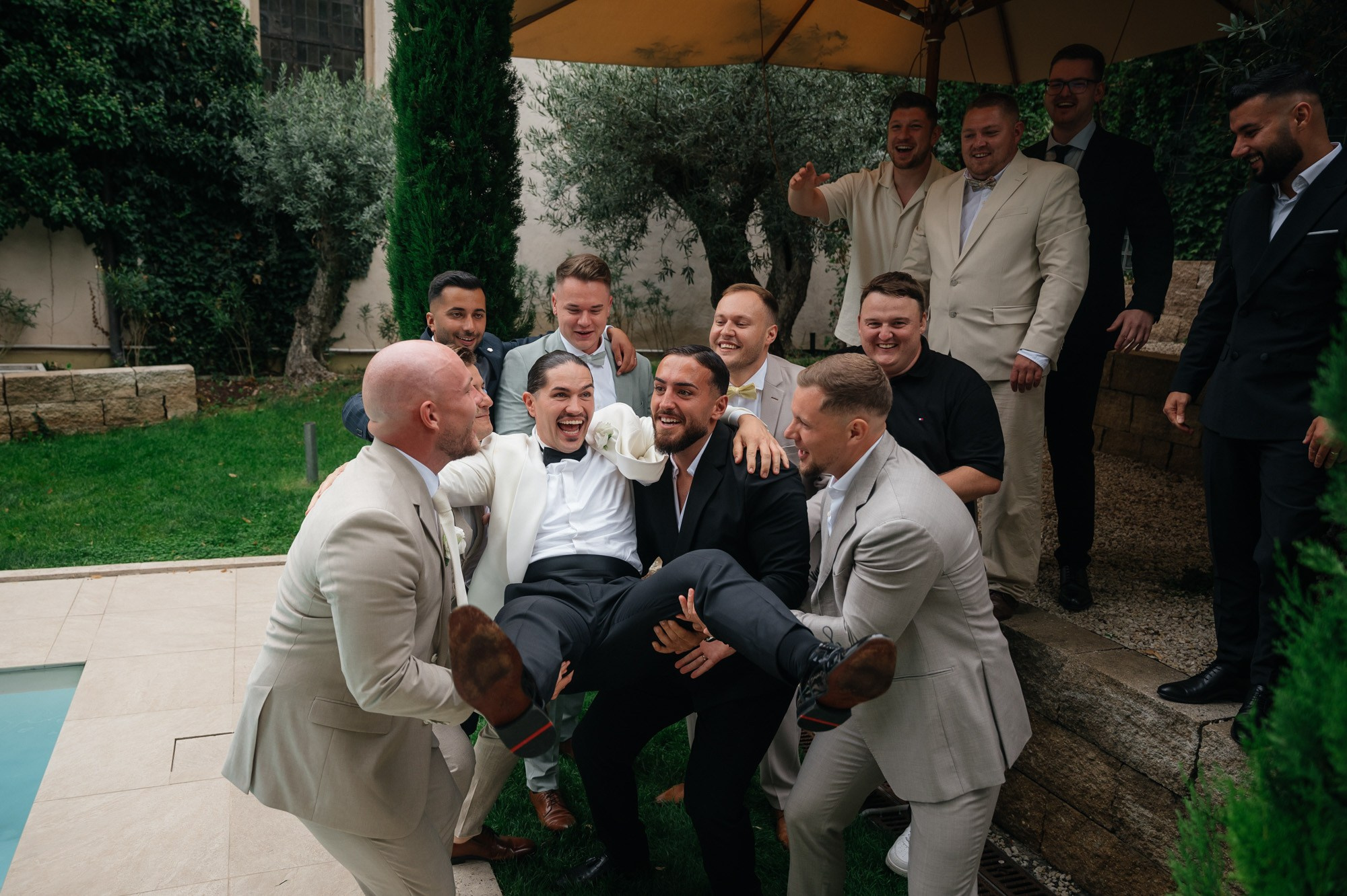 Friends throwing the groom up in the air