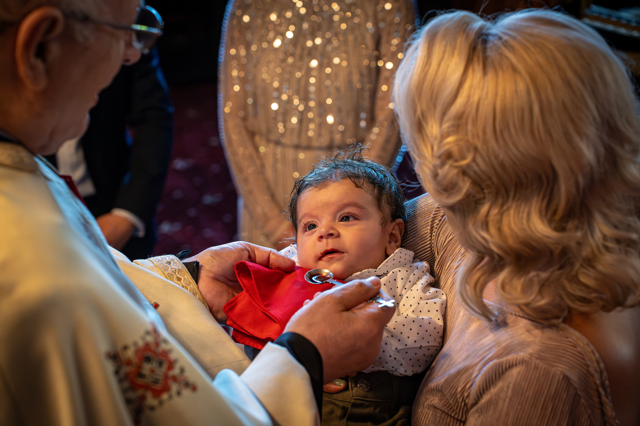 bebelus care primeste taina botezului