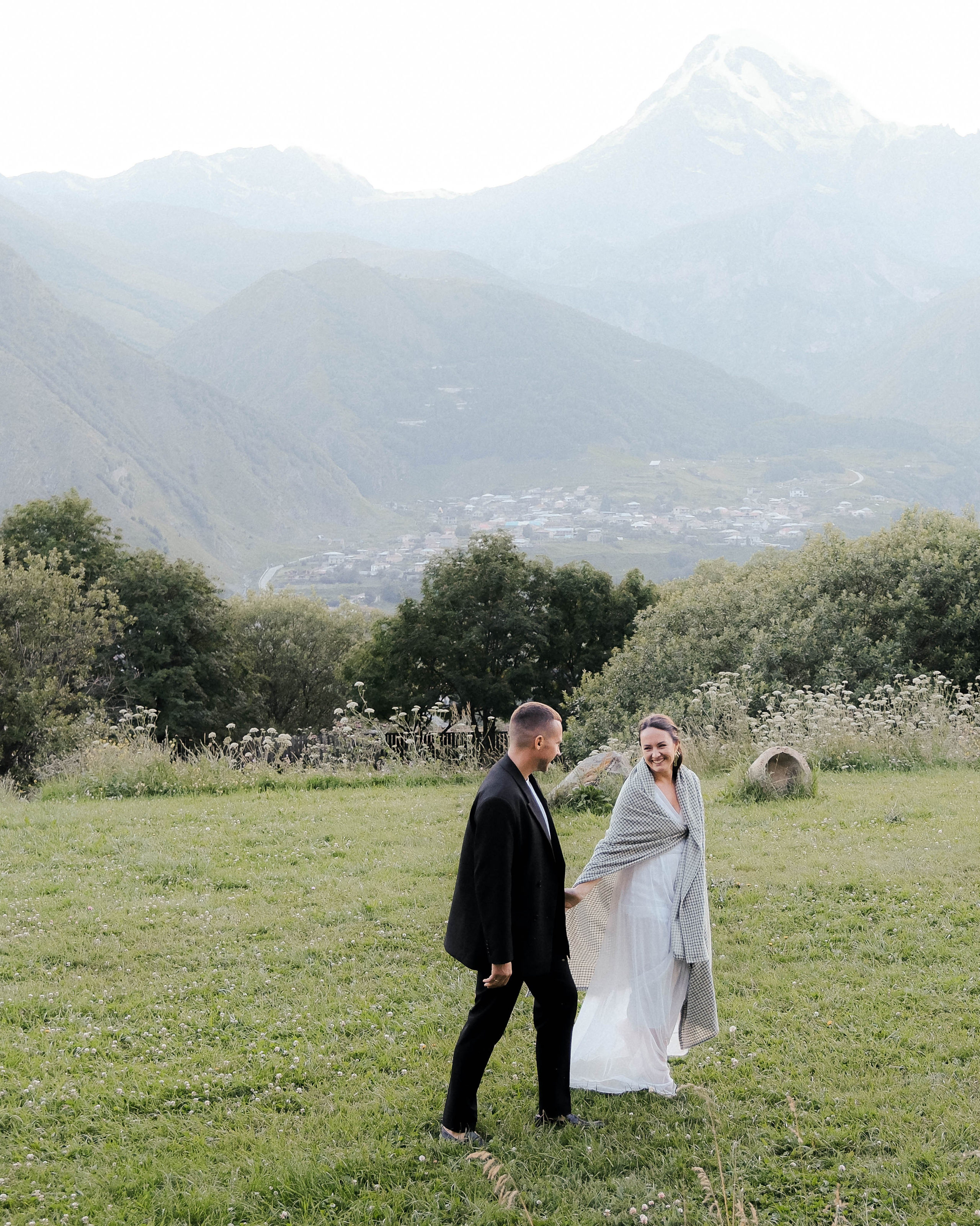 Groom and bride laughing during post-wedding photoshoot in Kazbegi