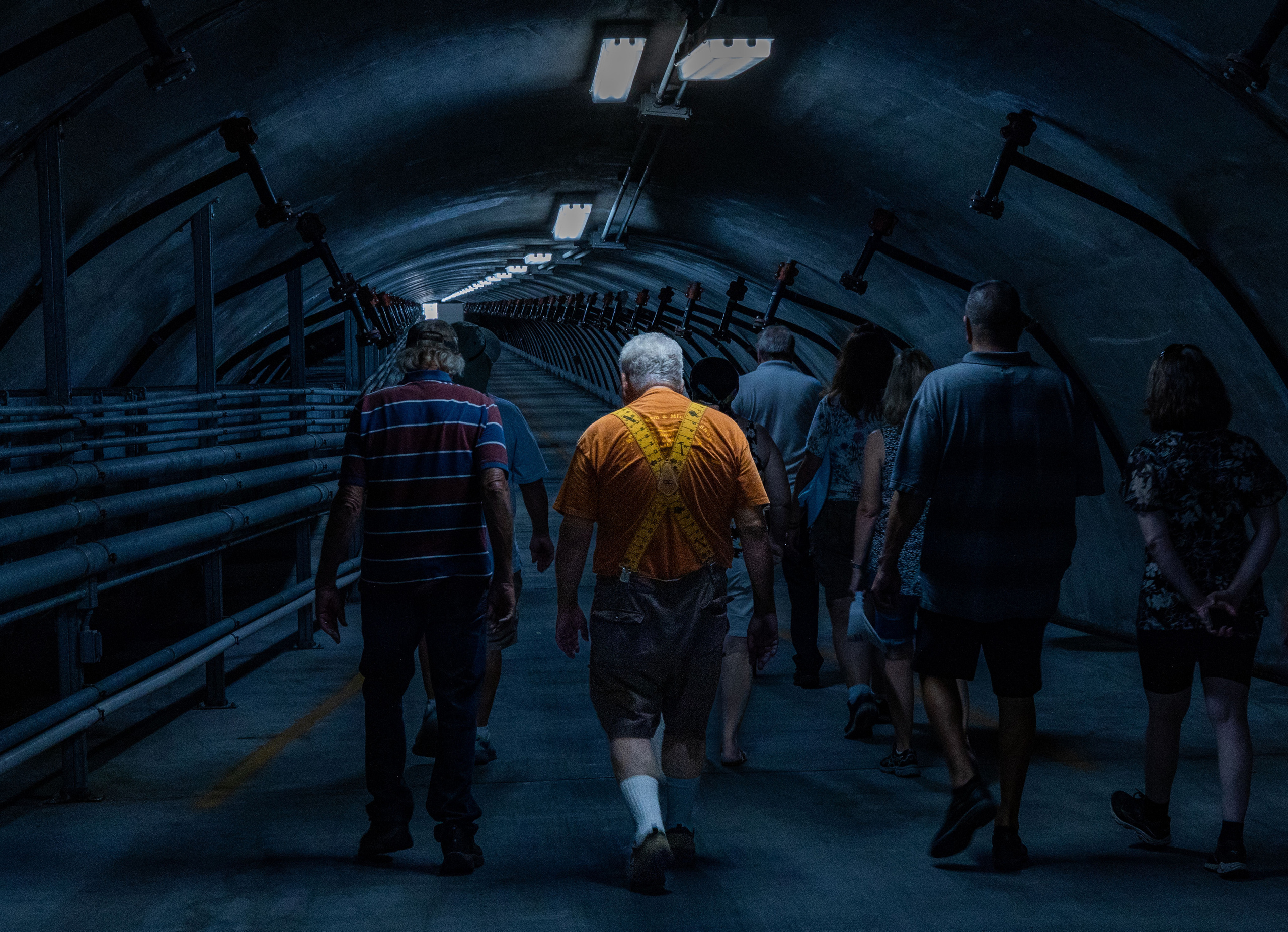 Under the massive 7 Oaks Dam in California, a group of rock hounders makes its way through a long, dark tunnel. Drops of water fall steadily from the ceiling, echoing like whispers of an unseen force. Overhead looms an immense reservoir—its weight pressing down like an ancient, restless monster. In the darkness, every step carries both awe and unease, a reminder of the fragile line between human curiosity and the raw power of nature.