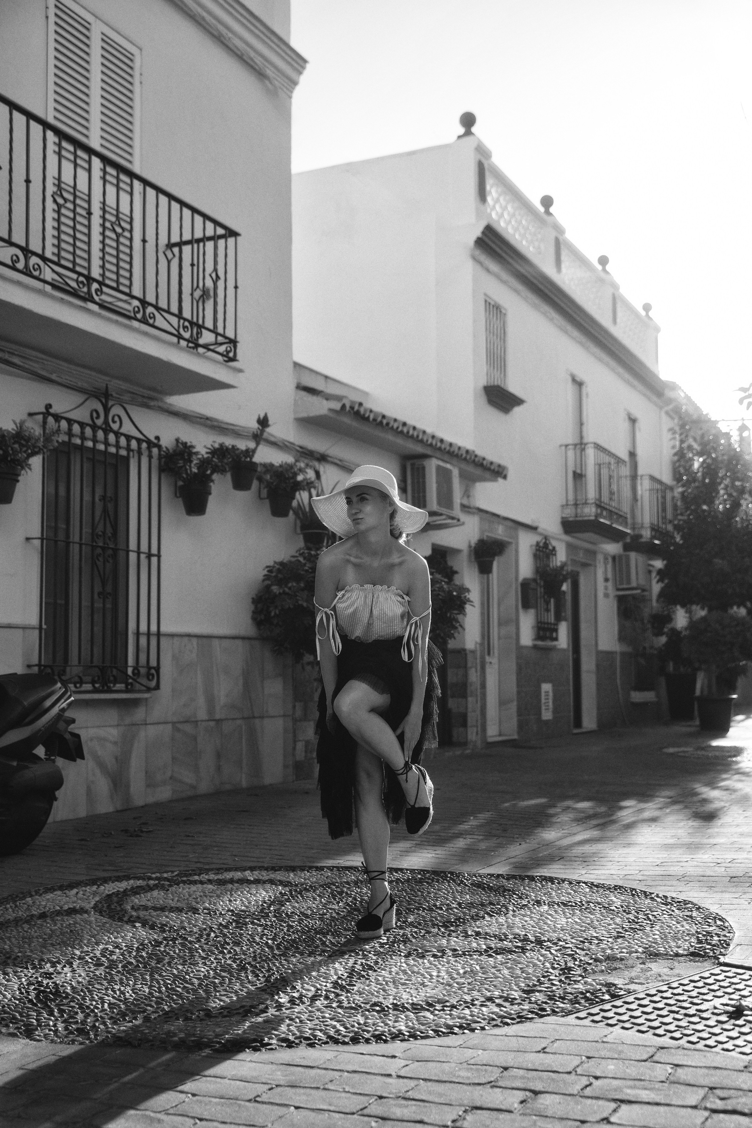 Elegant blonde woman posing in the quaint streets of Estepona old town, captured by a female portrait photographer