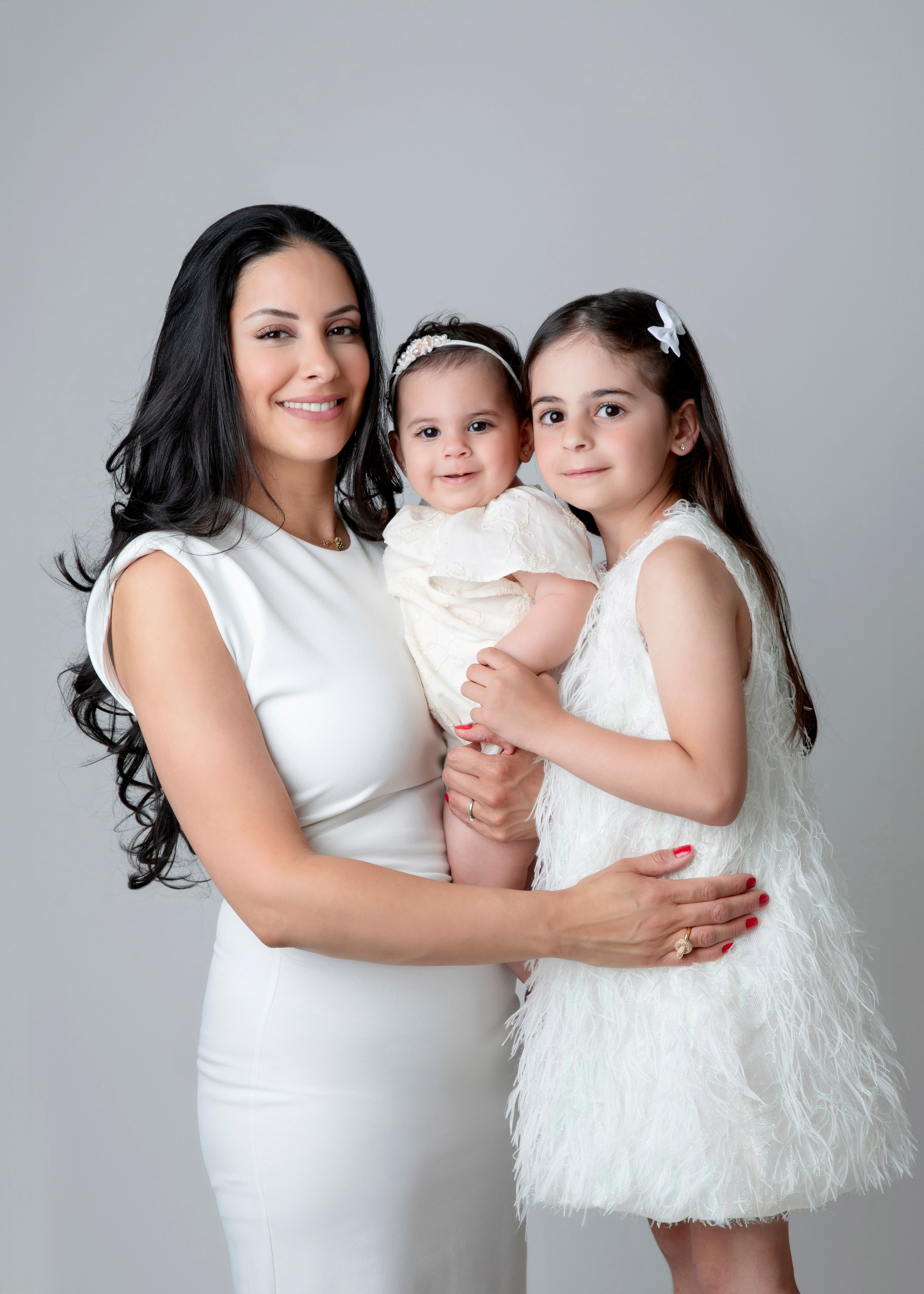 Familjefotografering i studion fångar ögonblicket av lycka med barn, mamma och pappa tillsammans.