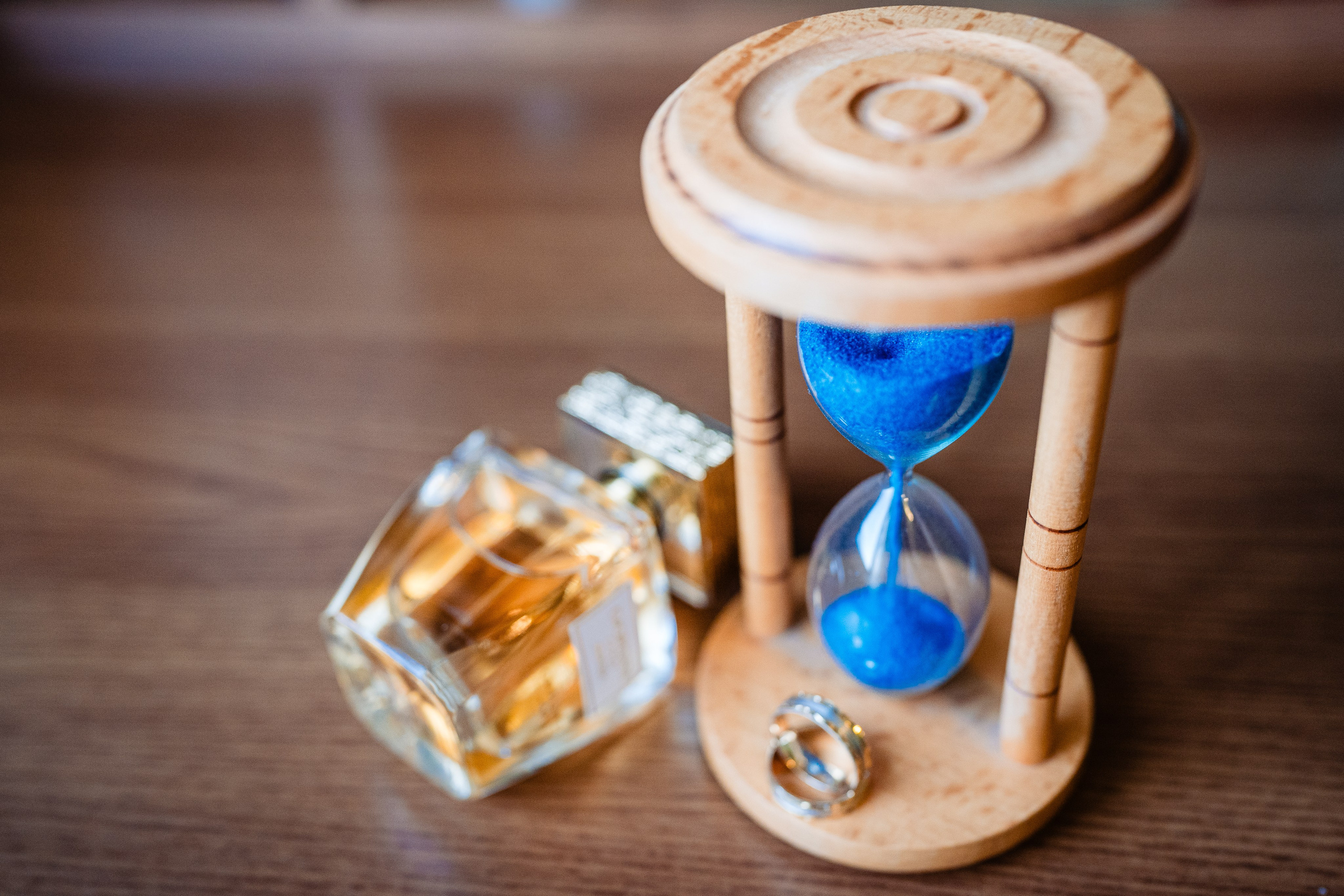 Detalii cu verighetele, parfumul și invitațiile pe o masă elegantă