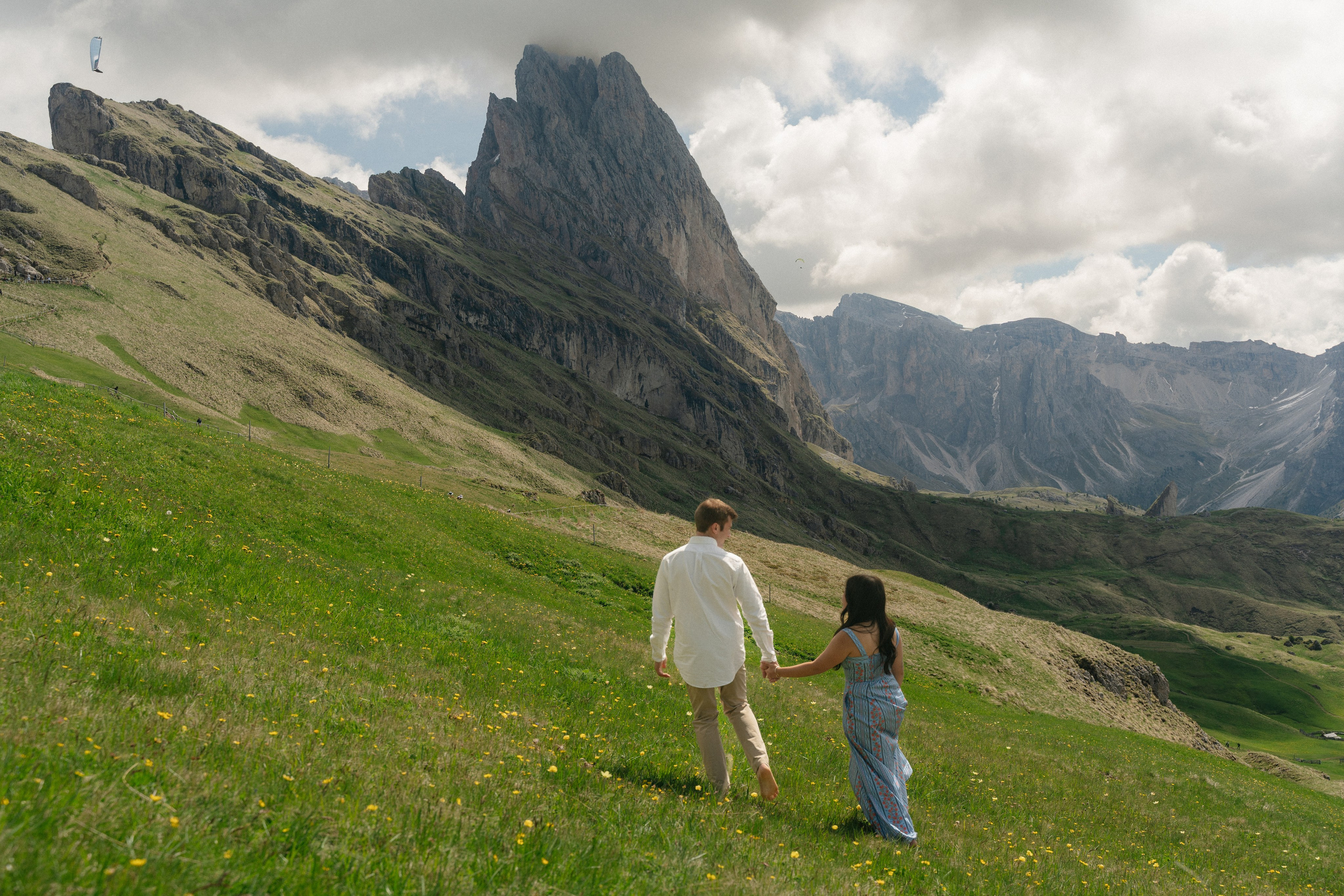 couple walking together after a surprise proposal at Seceda with panoramic mountain views