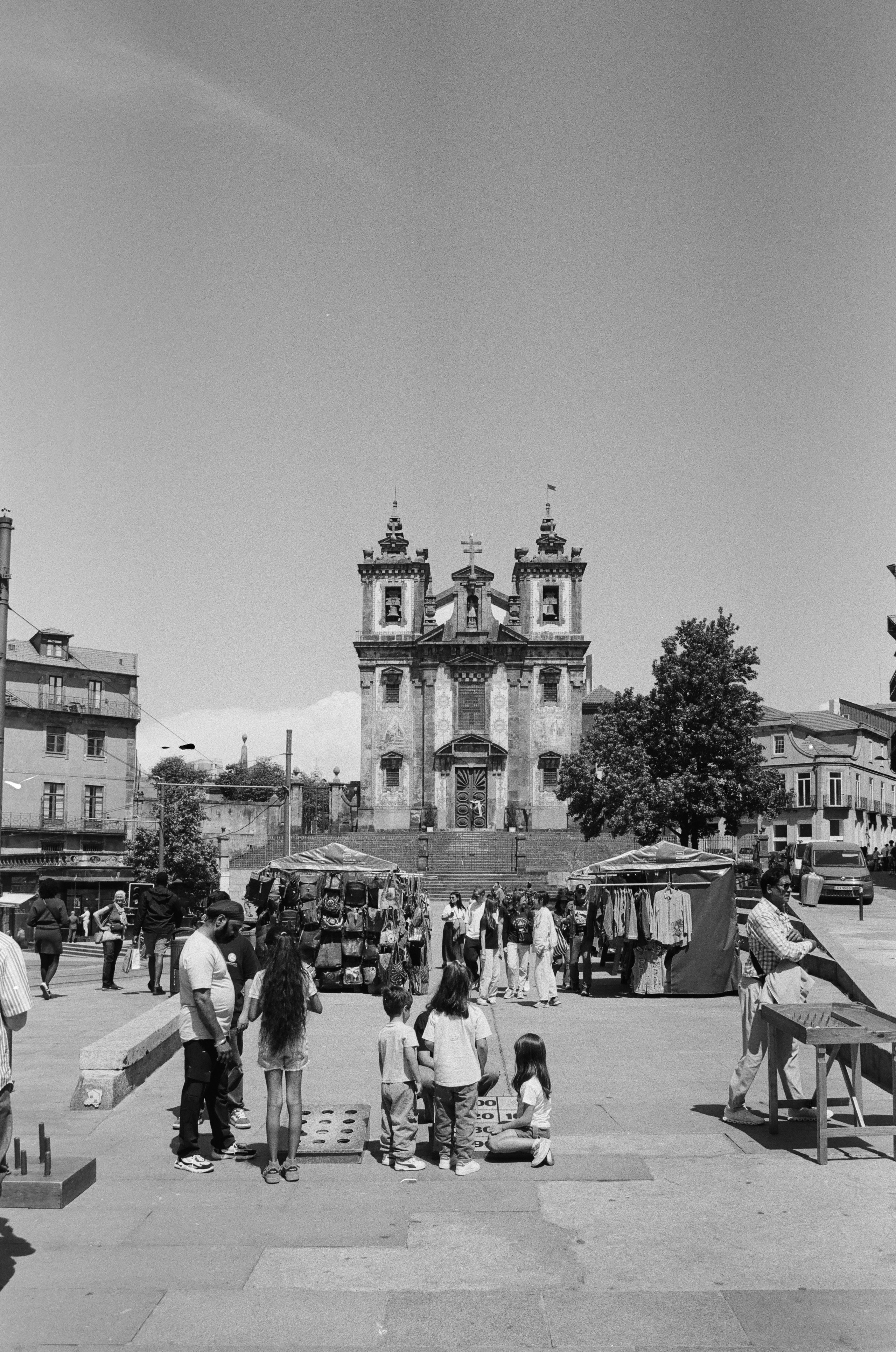 Kirche auf einem Platz in Porto mit Markt und Menschen